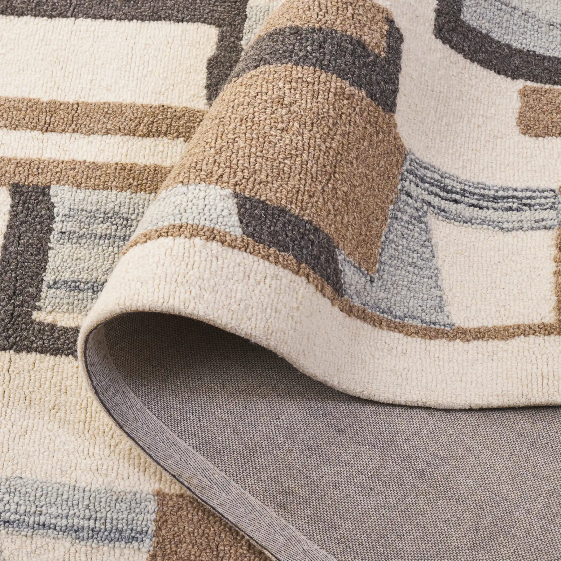 Ebony Abstract Patchwork Collage Hand-Tufted Wool Rug in Ivory / Brown in a styled room