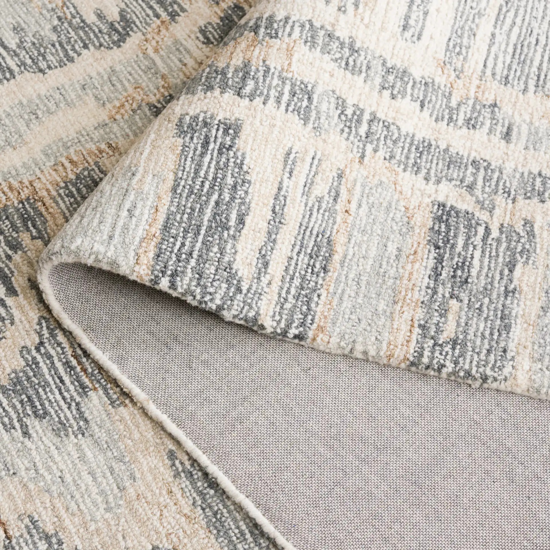 Ebony Distressed Abstract Hand-Tufted Wool Rug in Gray / Ivory in a styled room