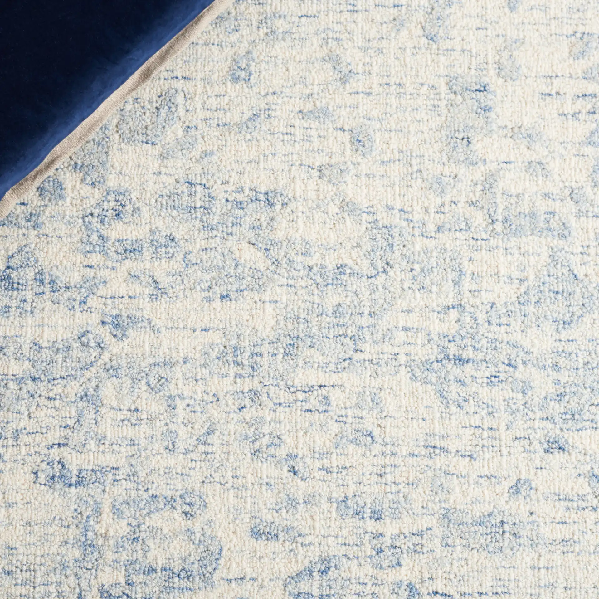 Ebony Abstract Mottled Hand-Tufted Wool Rug in Ivory / Blue in a styled room