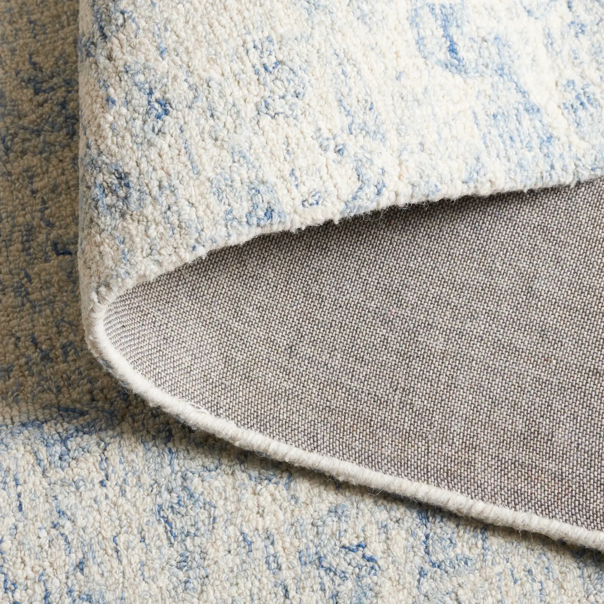 Ebony Abstract Mottled Hand-Tufted Wool Rug in Ivory / Blue in a styled room