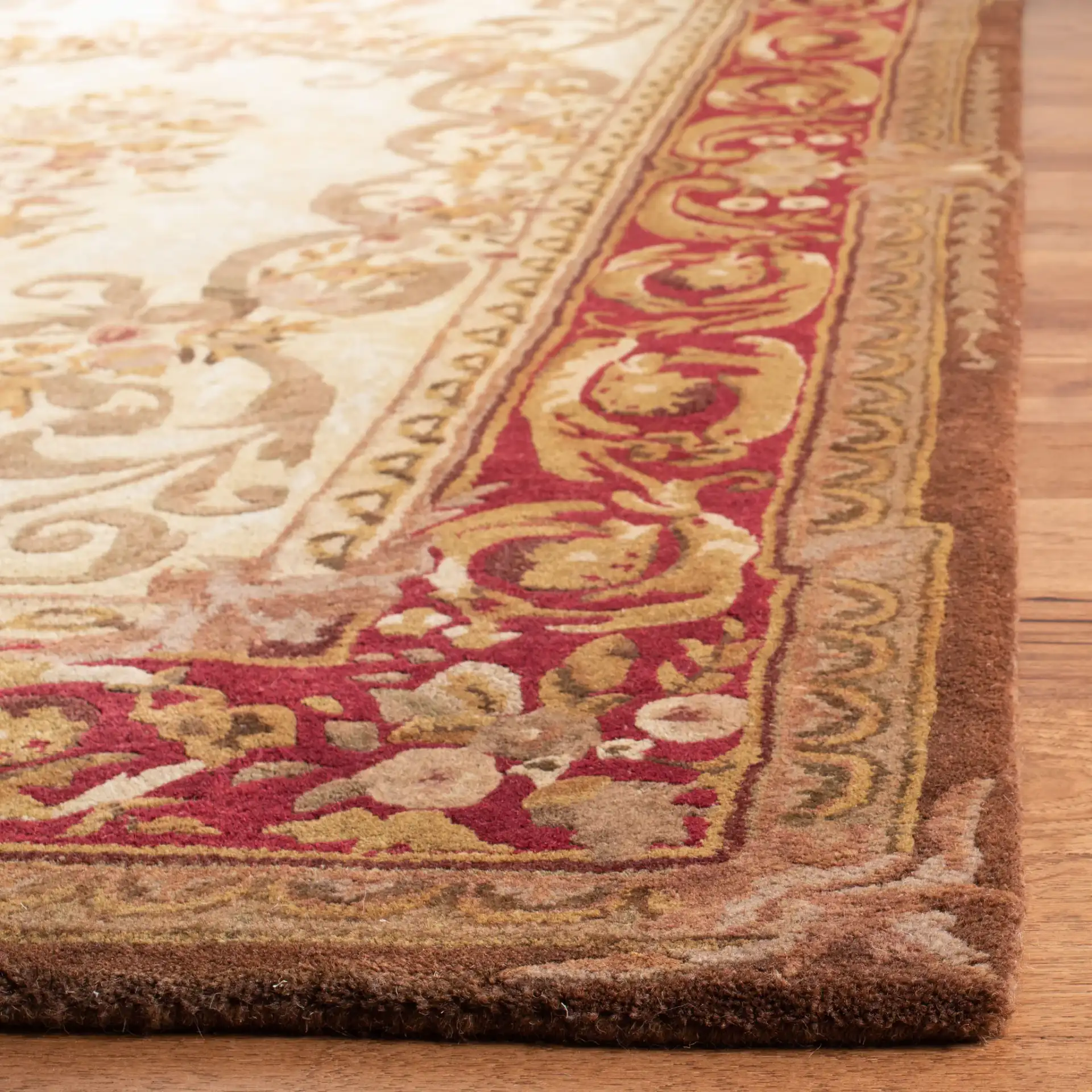 Empire Oval Medallion Bordered Hand-Tufted Wool Rug in Light Gold / Red in a styled room