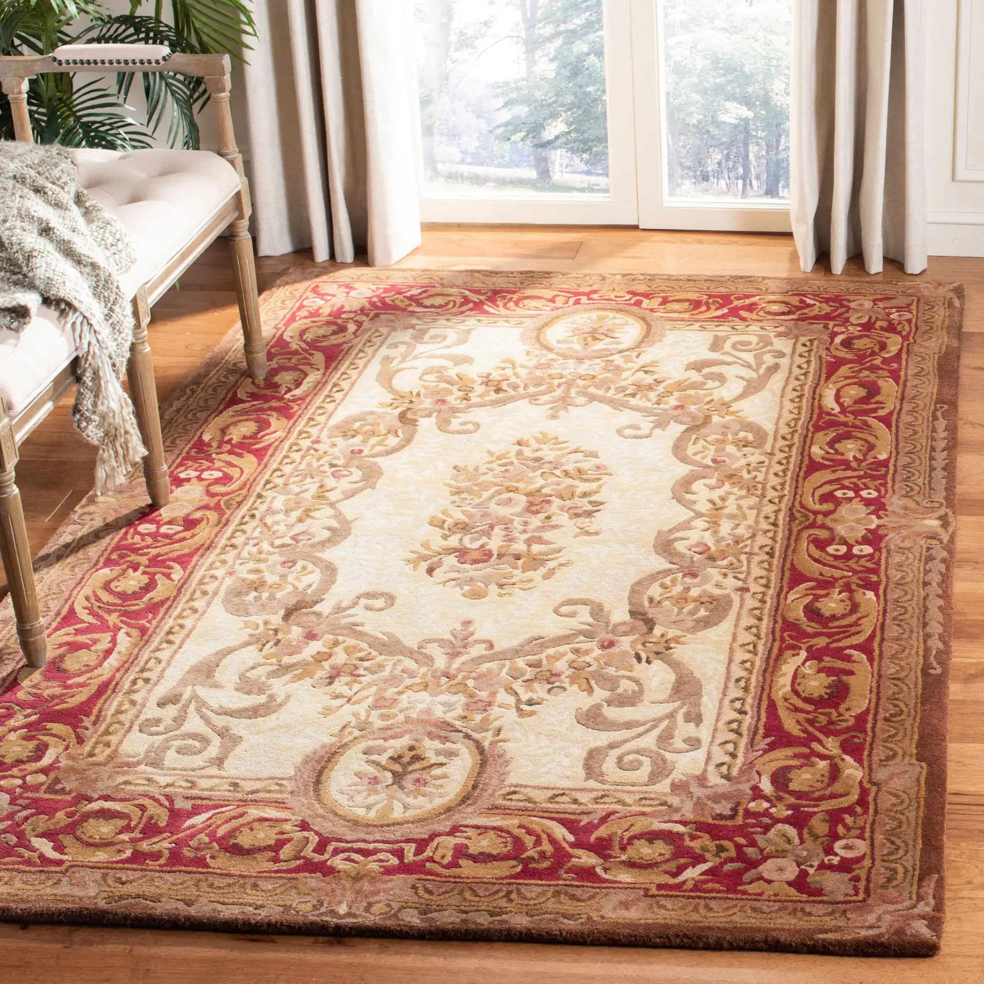 Empire Oval Medallion Bordered Hand-Tufted Wool Rug in Light Gold / Red in a styled room