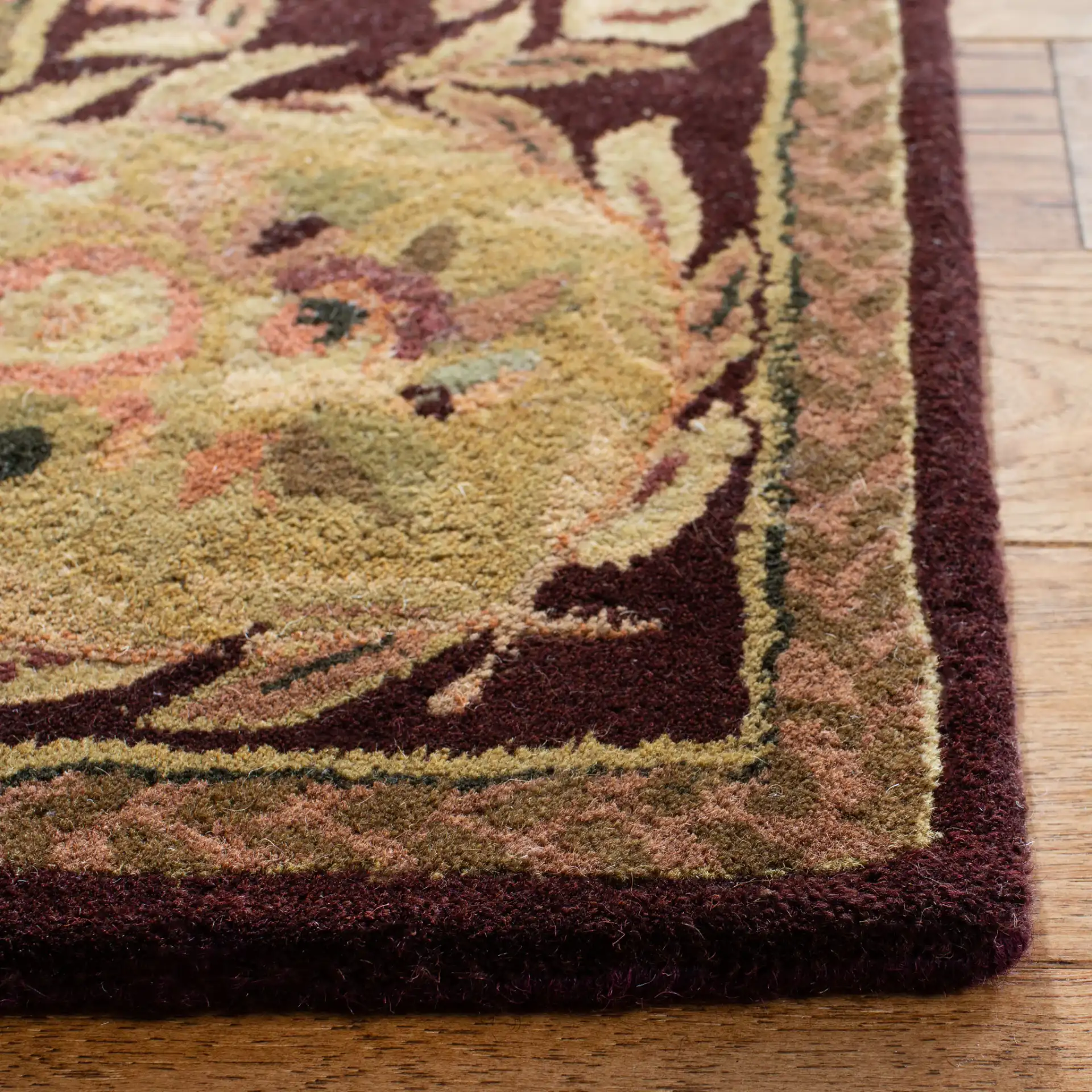 Empire Floral Rosette Bordered Hand-Tufted Wool Rug in Burgundy in a styled room