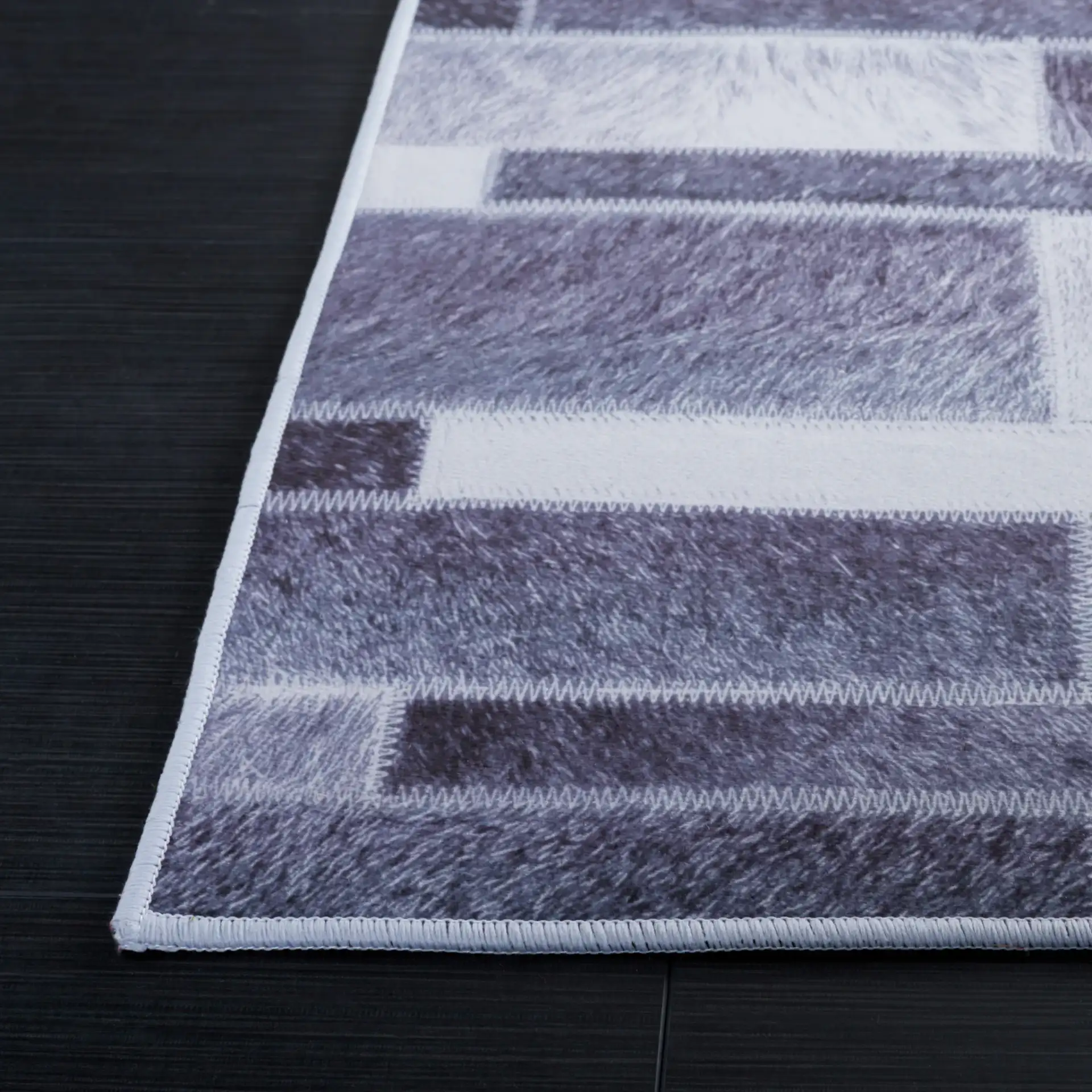 Faux Hide Linear Patchwork Washable Rug in Gray / Ivory in a styled room