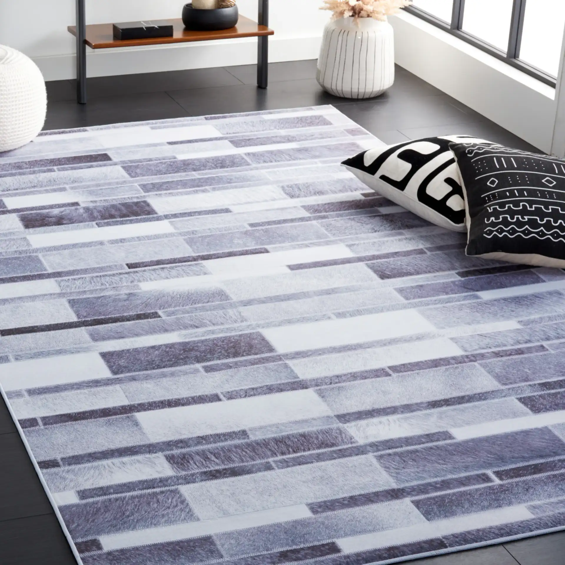 Faux Hide Linear Patchwork Washable Rug in Gray / Ivory in a styled room