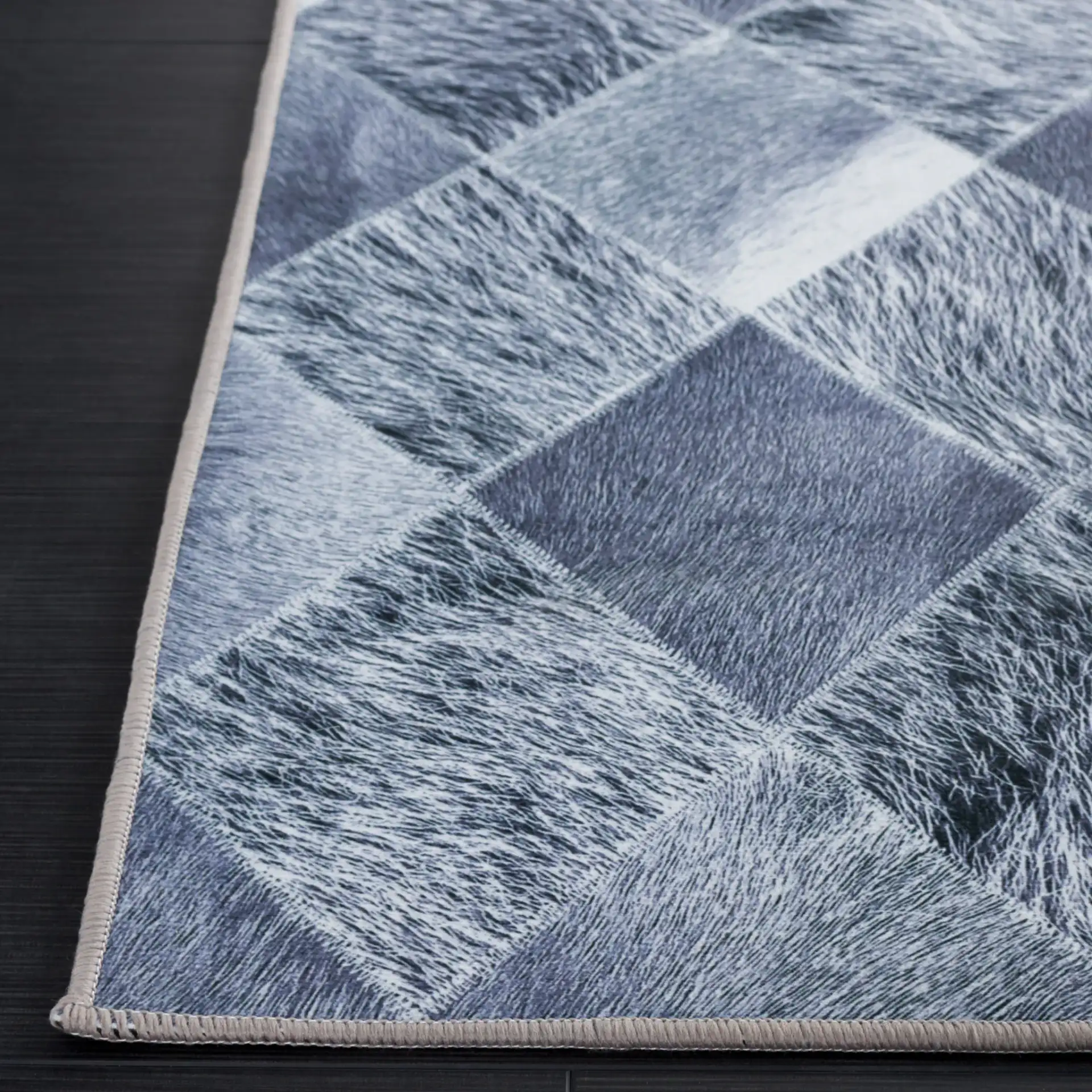 Faux Hide Harlequin Patchwork Washable Rug in Gray / Dark Gray in a styled room