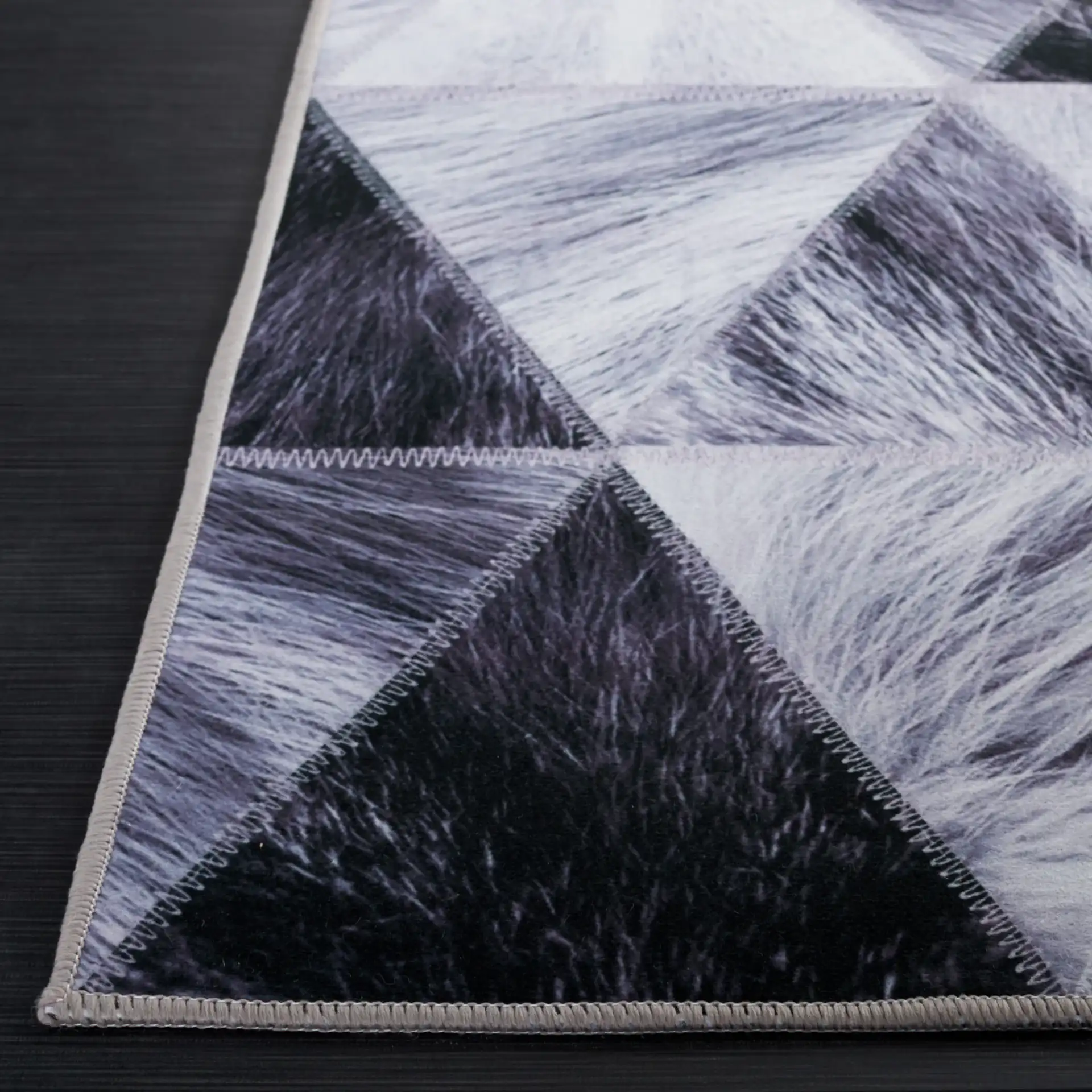 Faux Hide Triangle Patchwork Washable Rug in Light Gray / Dark Gray in a styled room