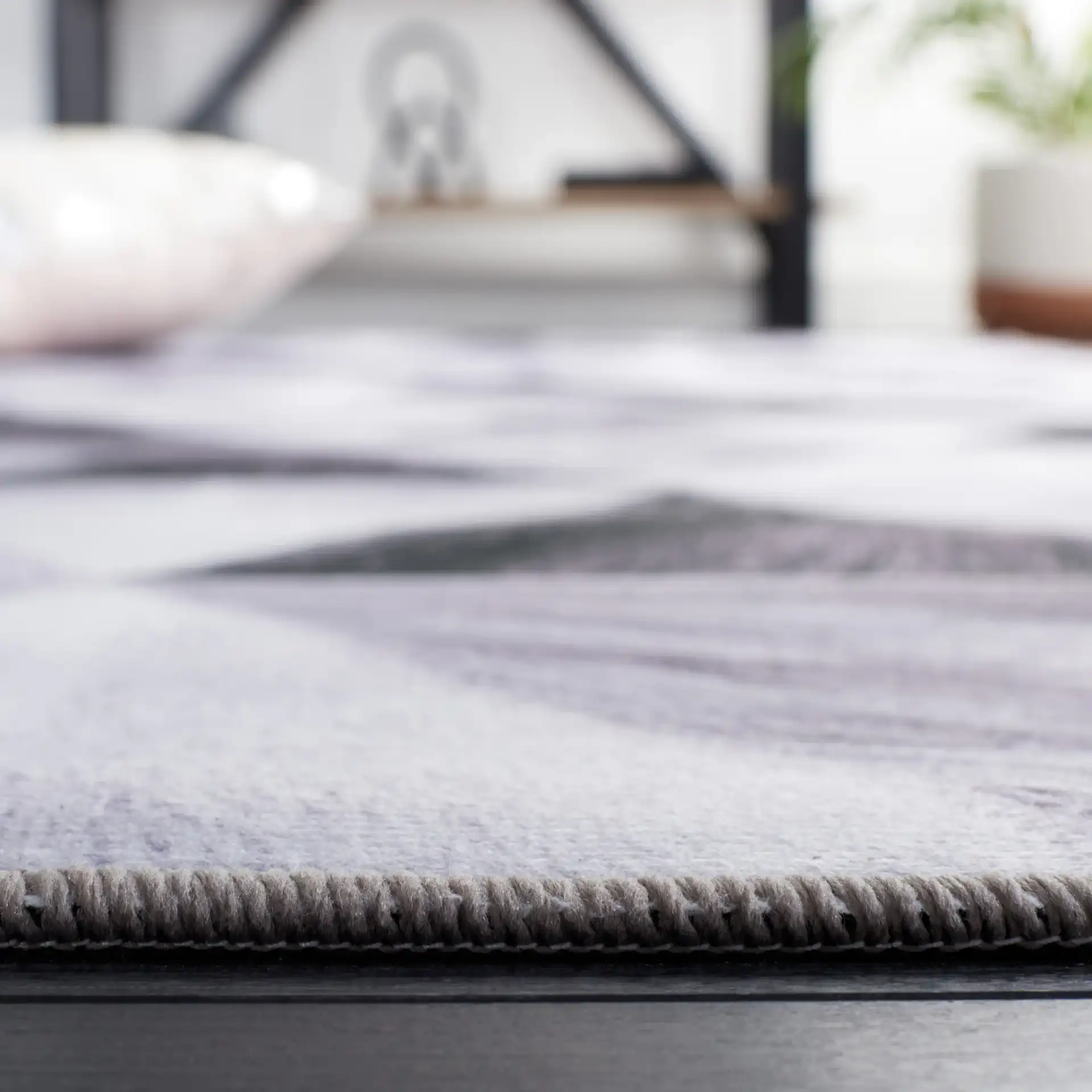 Faux Hide Triangle Patchwork Washable Rug in Light Gray / Dark Gray in a styled room