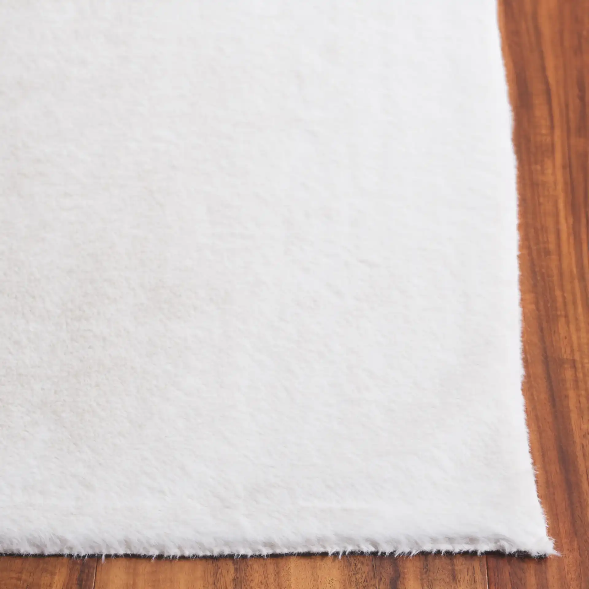 Faux Fur Solid Washable Rug in Ivory in a styled room