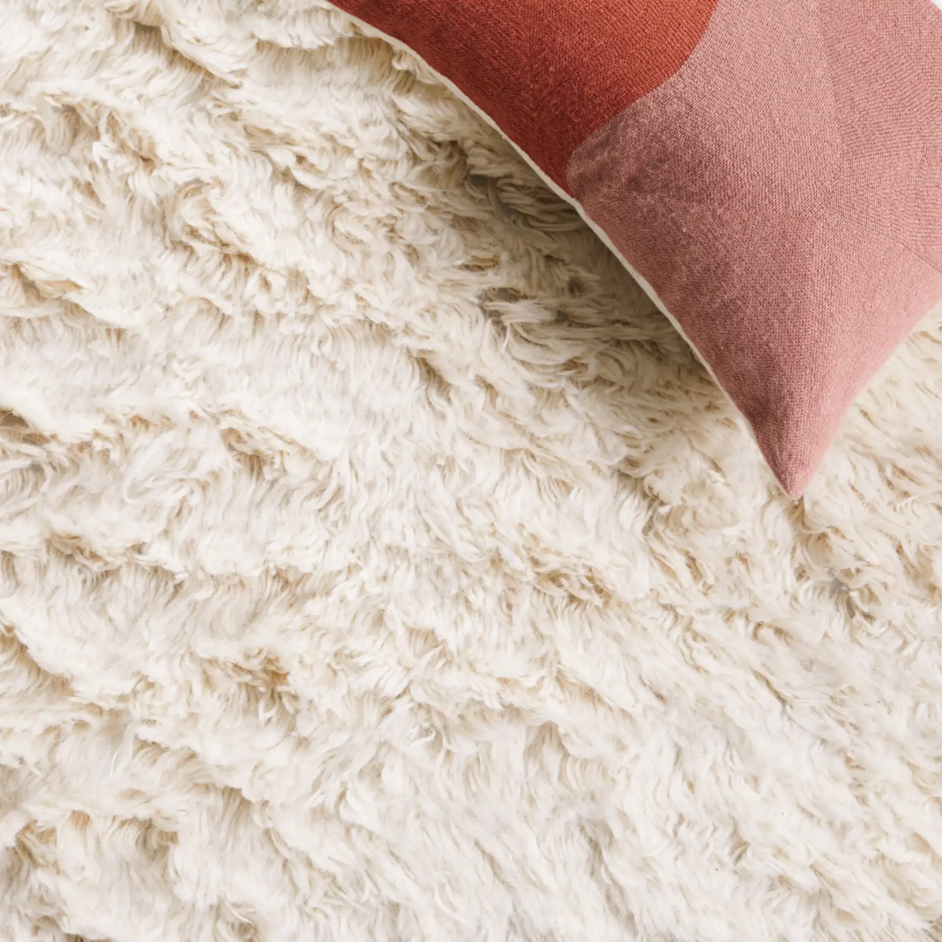 Flokati Solid Hand-Tufted Wool Shag Rug in Ivory in a styled room