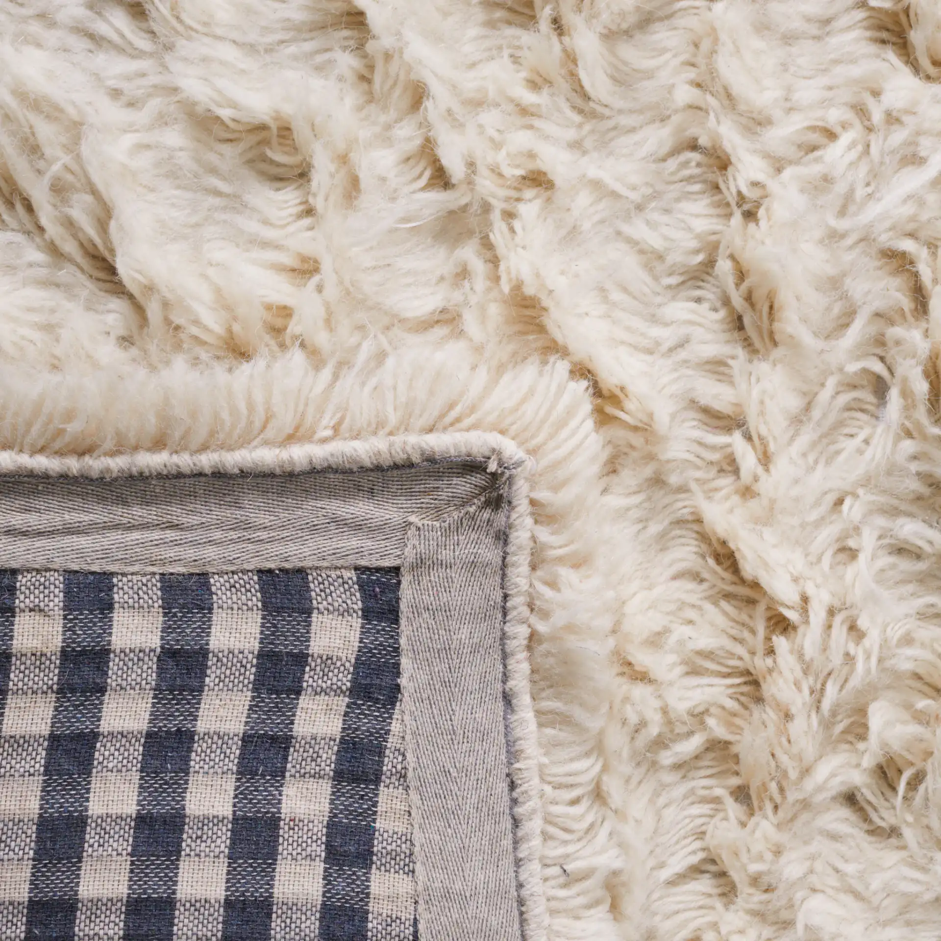 Flokati Solid Hand-Tufted Wool Shag Rug in Ivory in a styled room