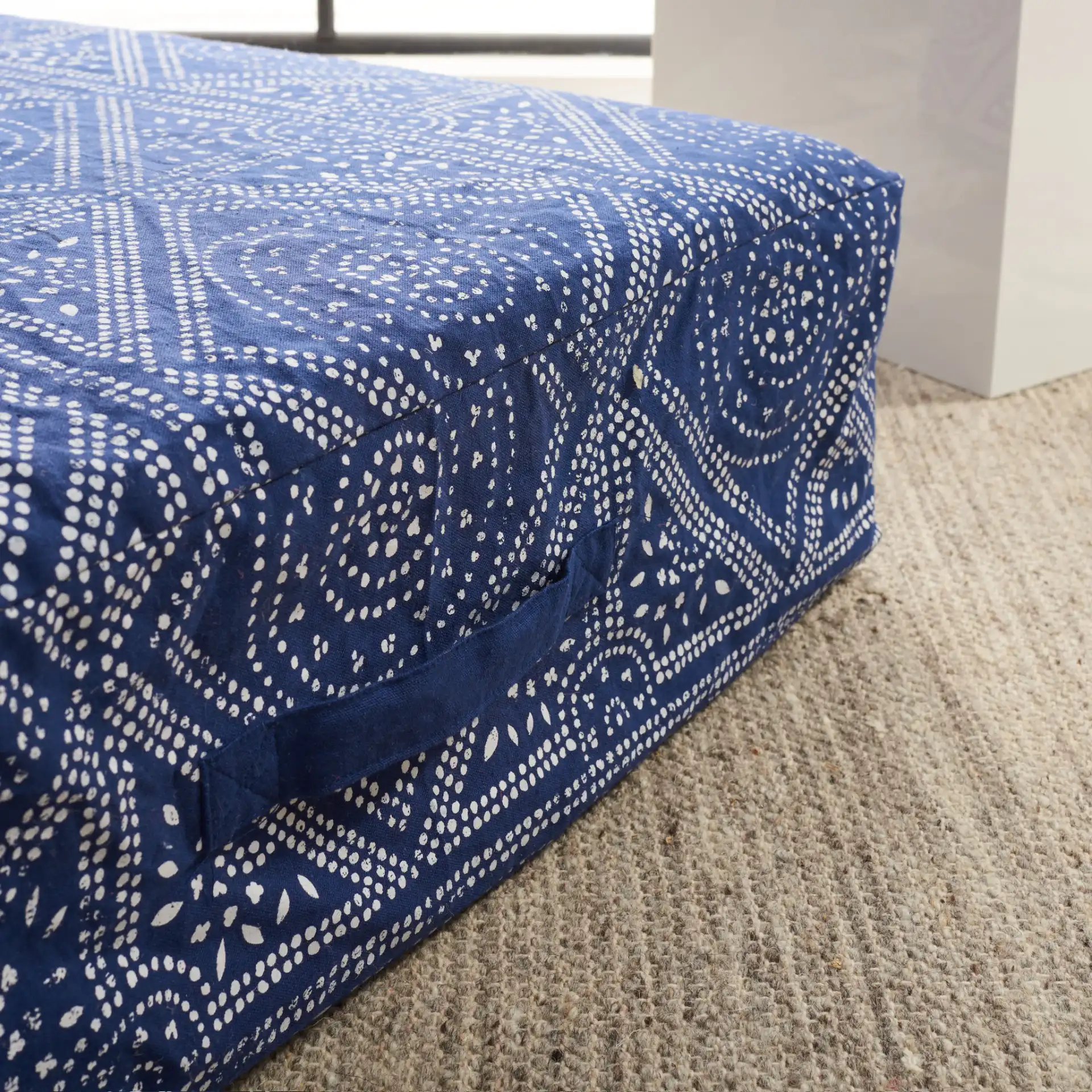 Valenti Square Floor Pillow in Navy Blue / White in a styled room