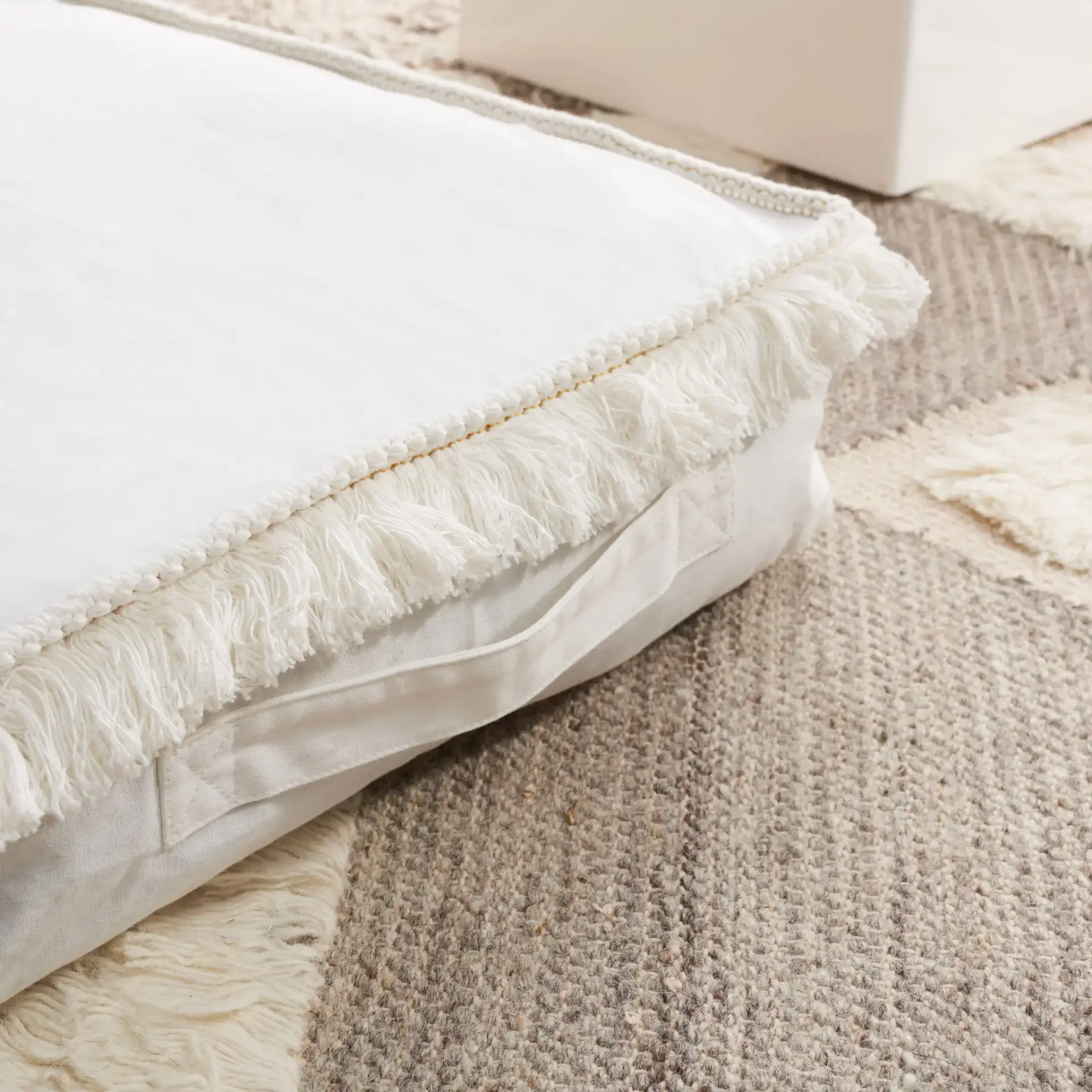 Grema Floor Pillow in Ivory in a styled room
