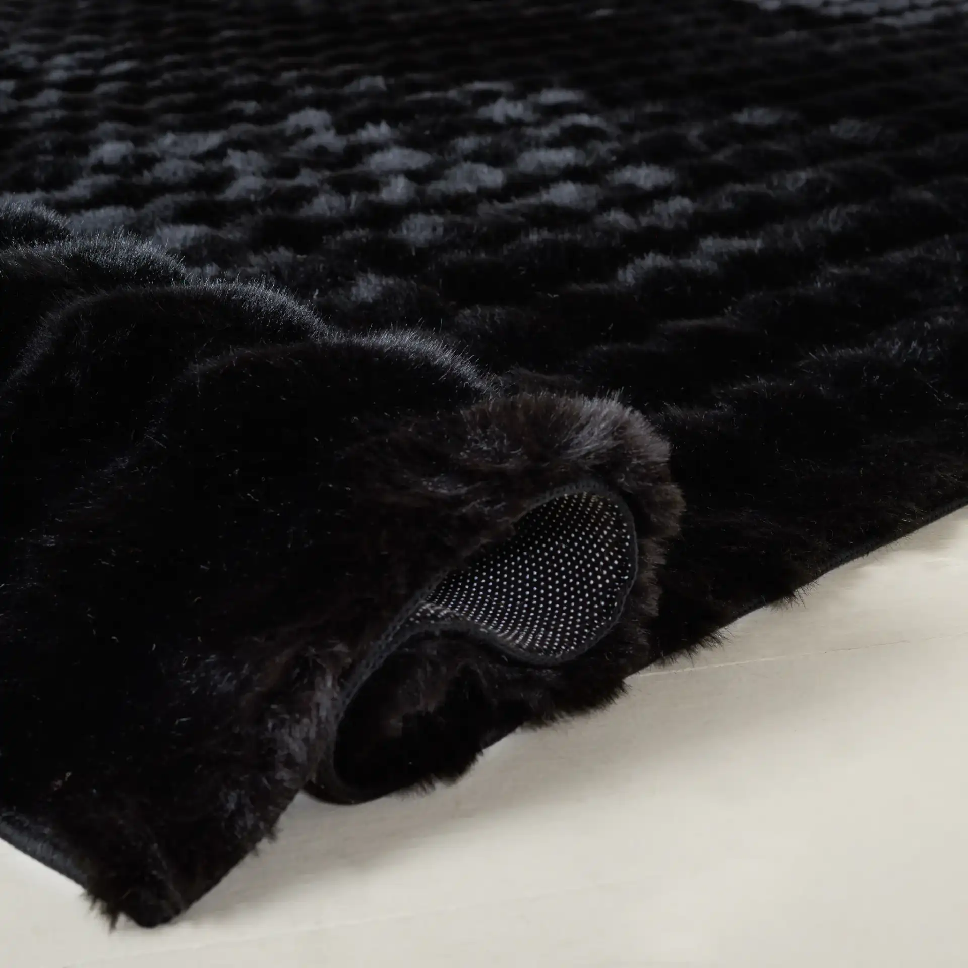 Faux Rabbit Bubble Textured Solid Washable Rug in Black in a styled room