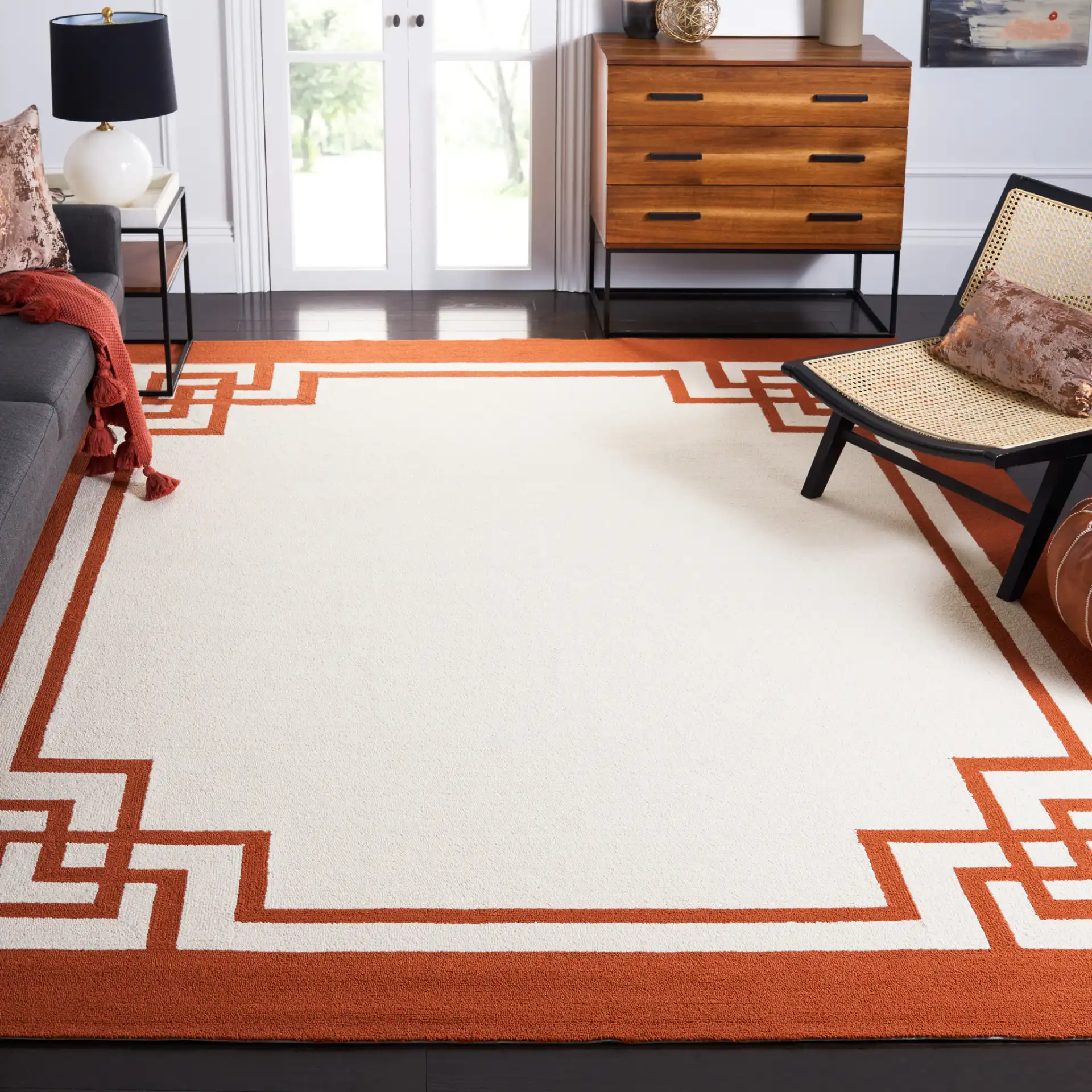 Four Seasons Greek Key Border Hand-Hooked Rug in Off-White / Sangria in a styled room