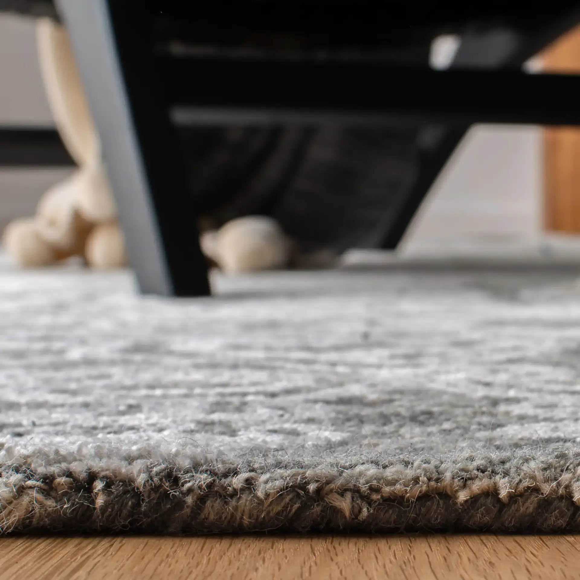 Glamour Distressed Damask Hand-Tufted Rug in Charcoal in a styled room