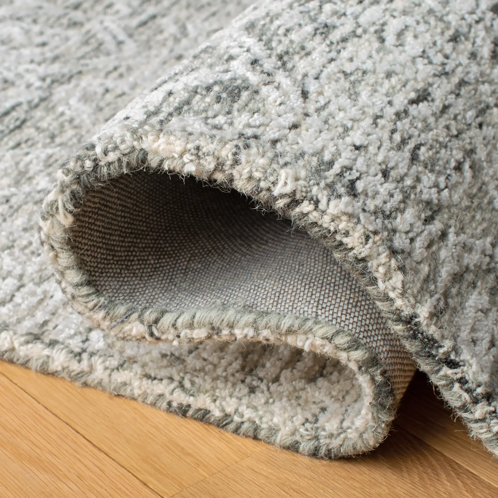 Glamour Distressed Damask Hand-Tufted Rug in Charcoal in a styled room