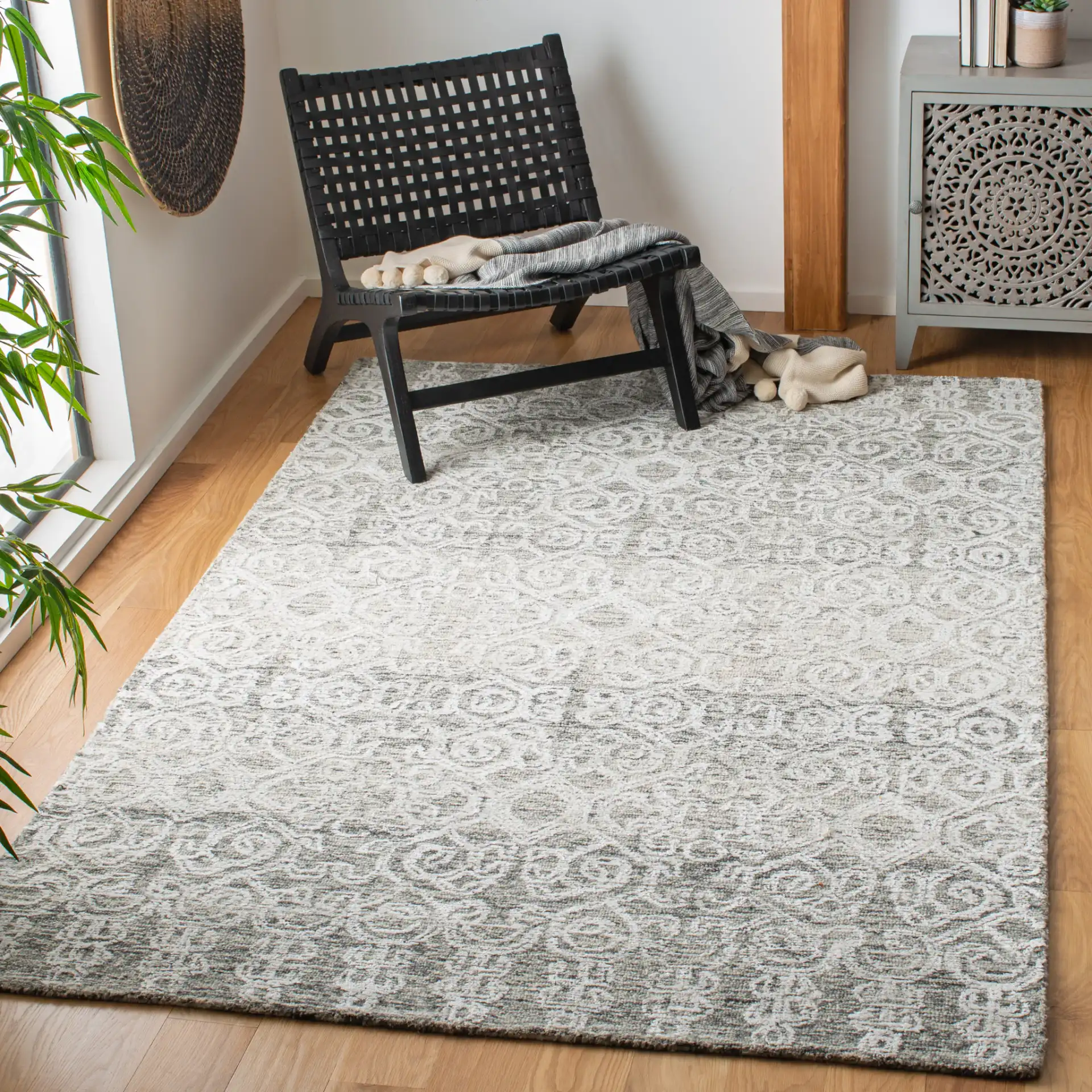 Glamour Distressed Damask Hand-Tufted Rug in Charcoal in a styled room