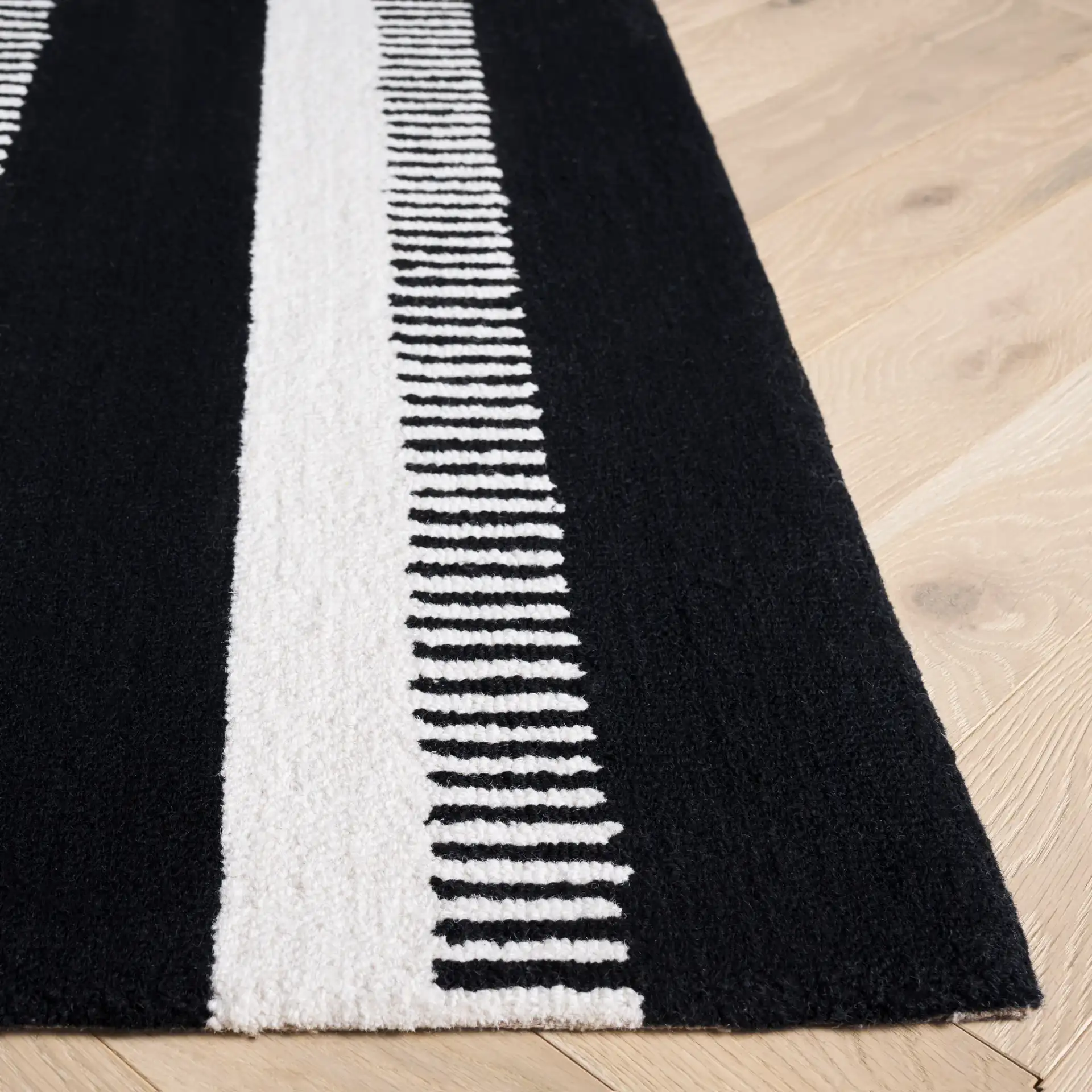 Genre Ladder Stripe Hand-Tufted Wool Rug in Black / Ivory in a styled room