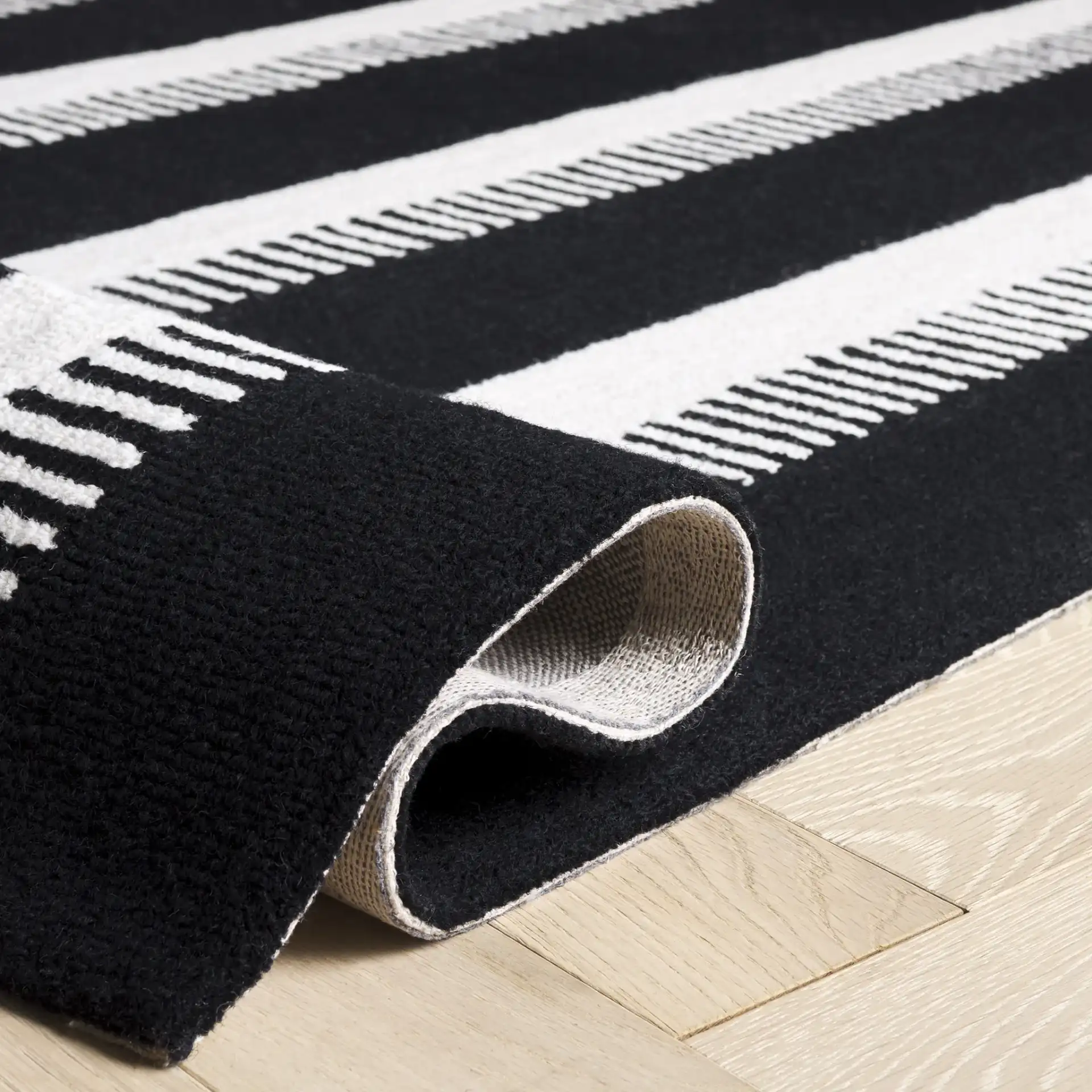 Genre Ladder Stripe Hand-Tufted Wool Rug in Black / Ivory in a styled room