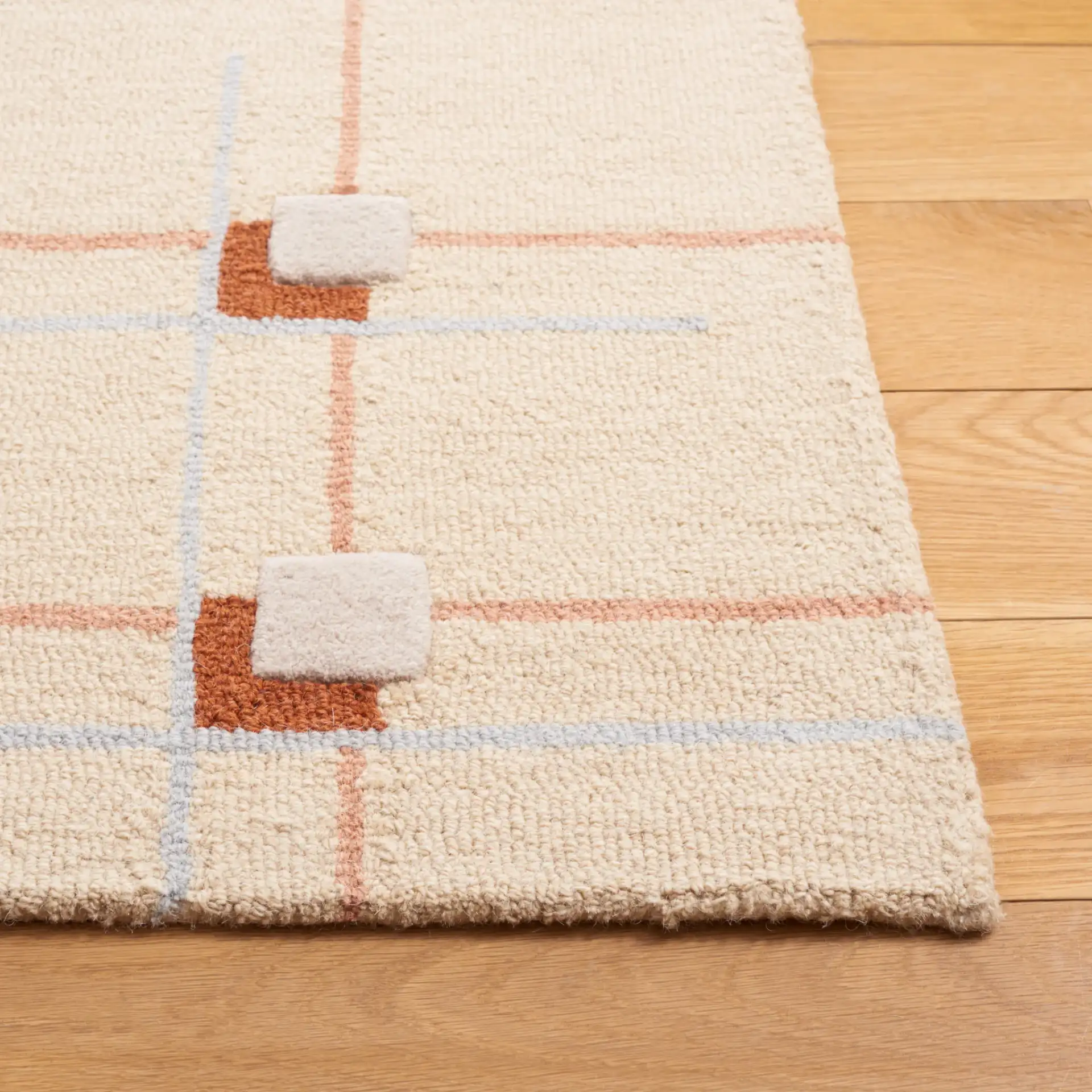 Genre Asymmetric Grid Hand-Tufted Wool Rug in Beige / Rust in a styled room