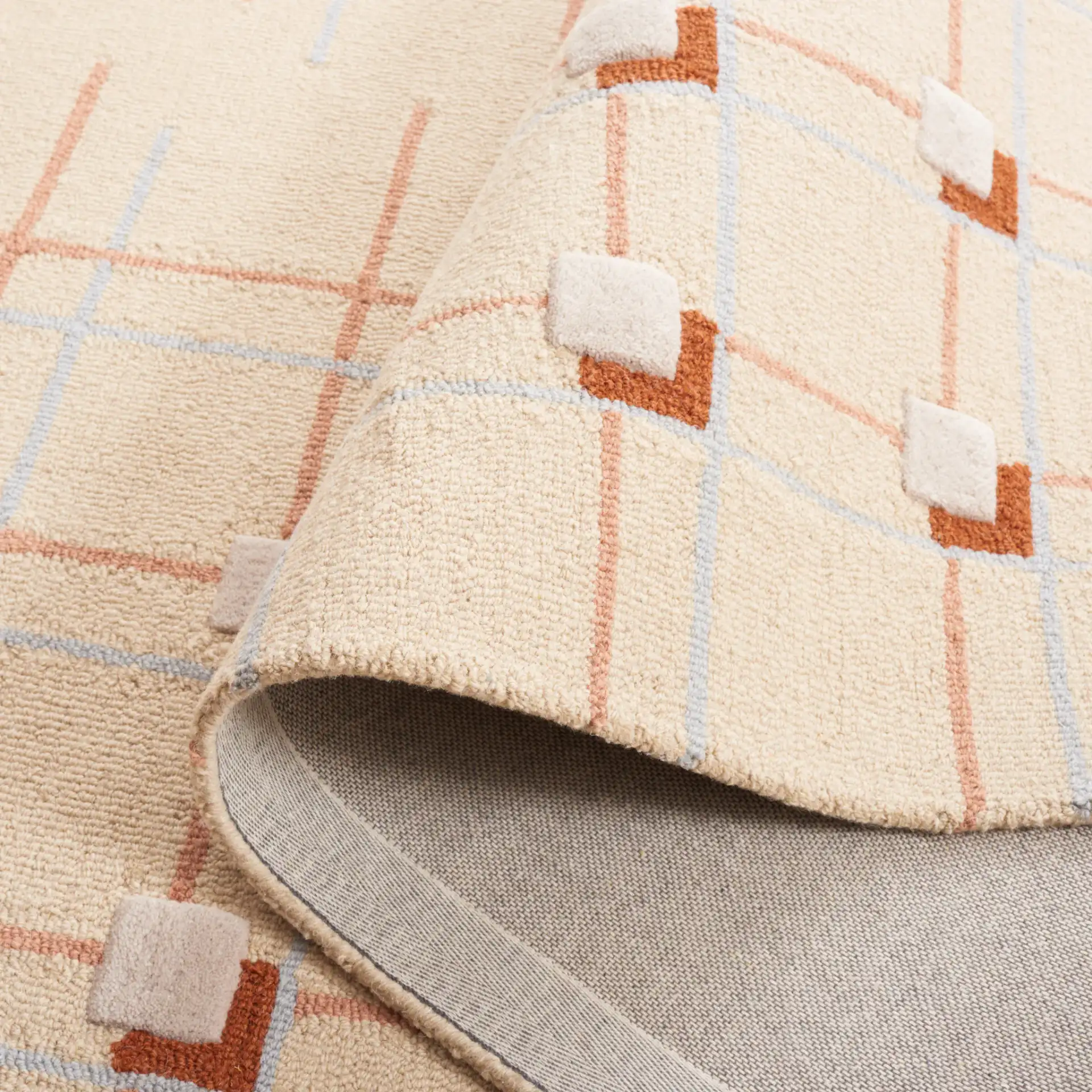 Genre Asymmetric Grid Hand-Tufted Wool Rug in Beige / Rust in a styled room