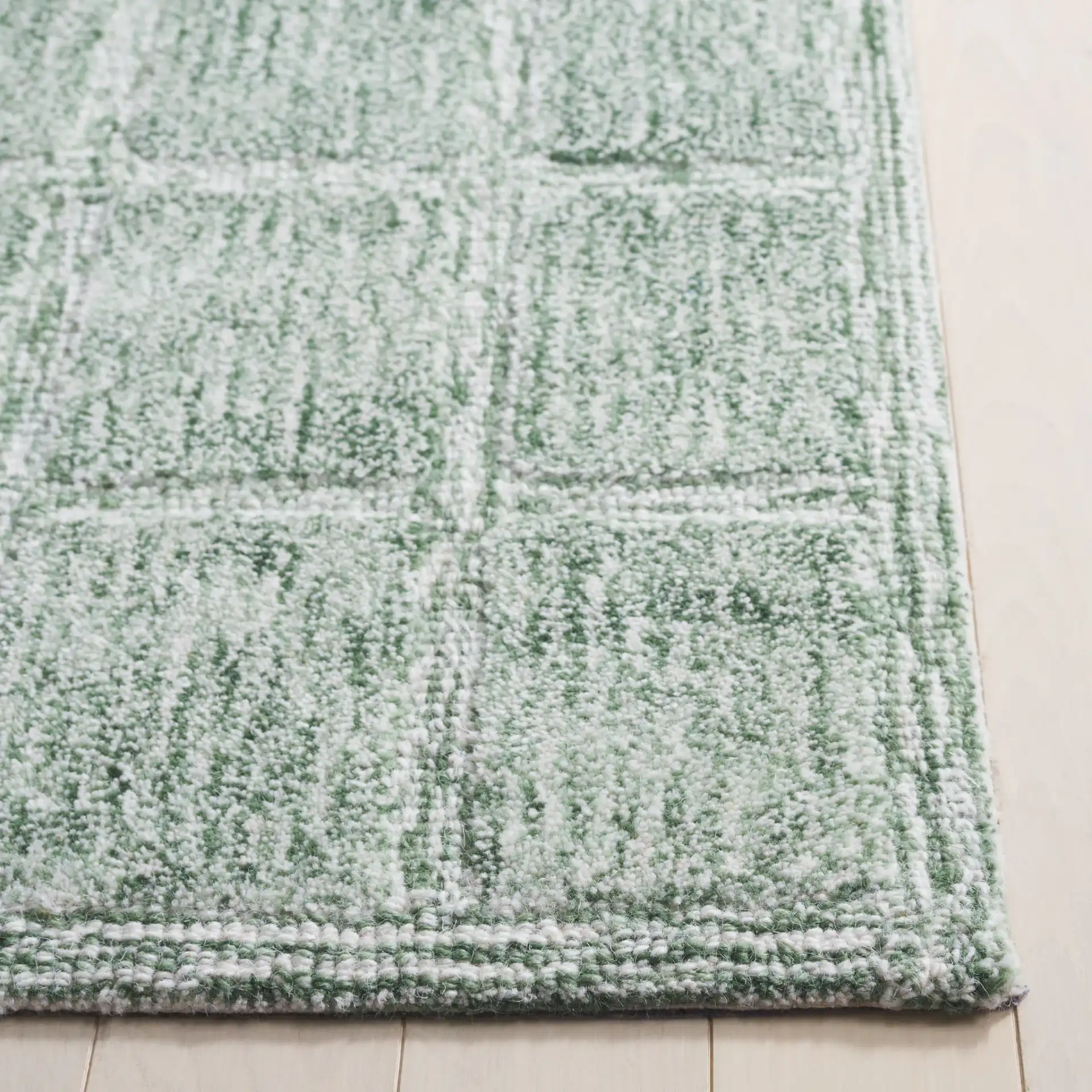 Genre Grid Hand-Woven Wool Rug in Green / Ivory in a styled room
