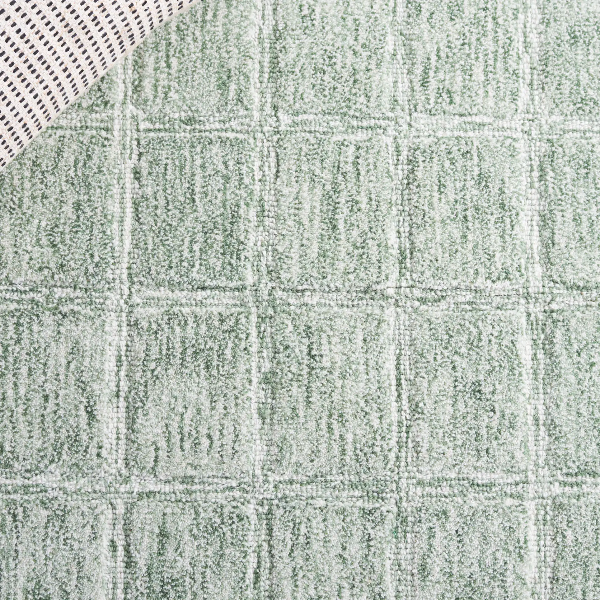 Genre Grid Hand-Woven Wool Rug in Green / Ivory in a styled room