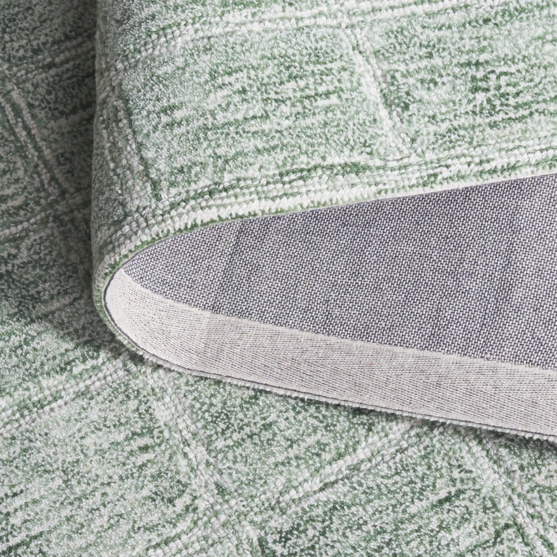 Genre Grid Hand-Woven Wool Rug in Green / Ivory in a styled room