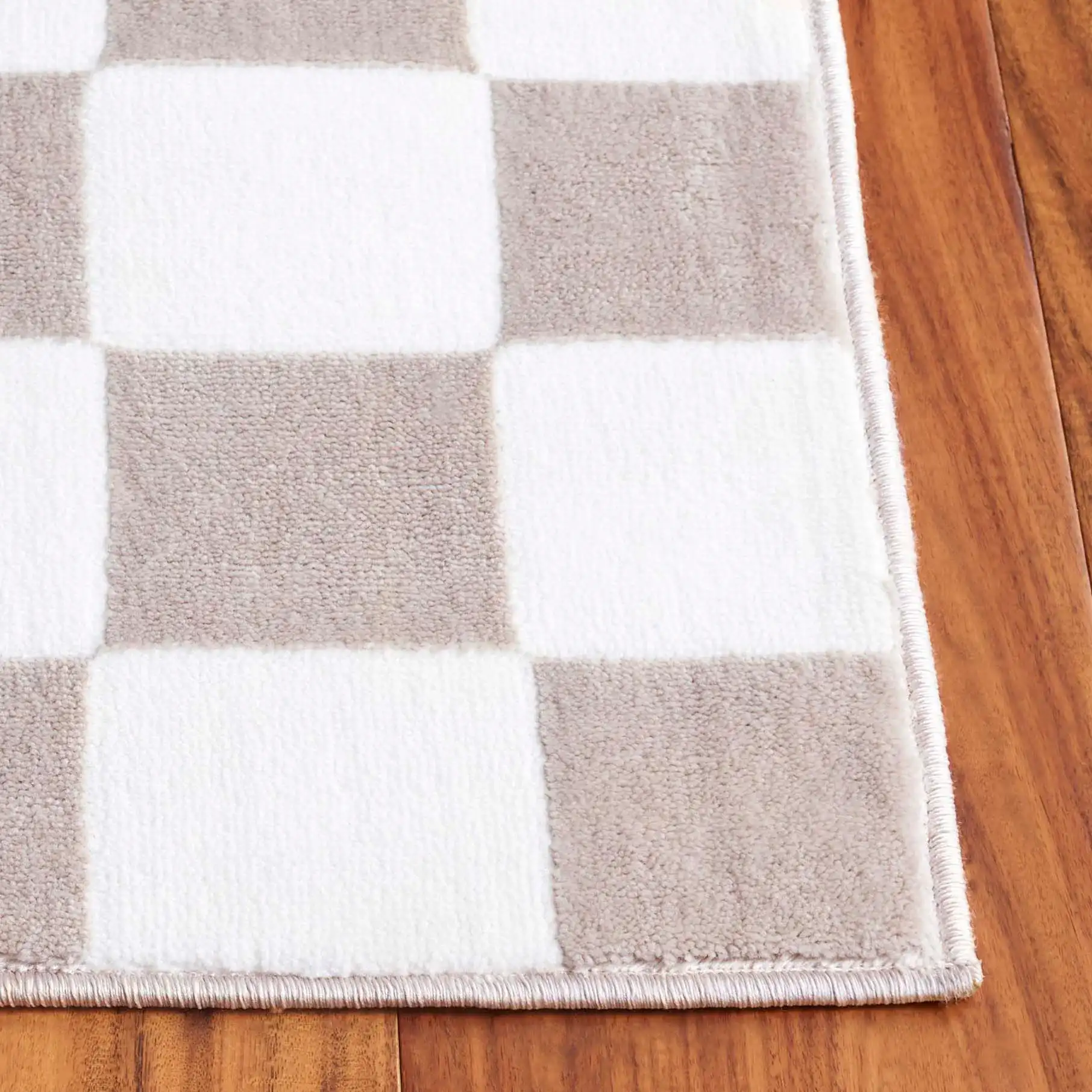 Groove Checkerboard Border Rug in Beige / Ivory in a styled room