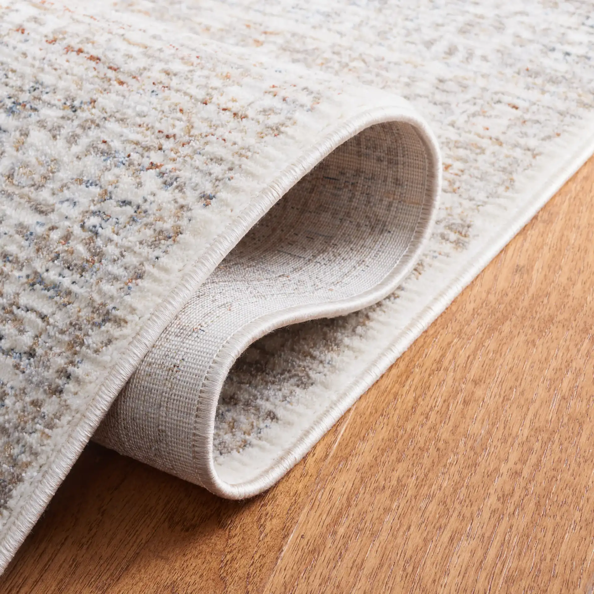 Harlow Faded Floral Bordered Rug in Ivory / Beige in a styled room