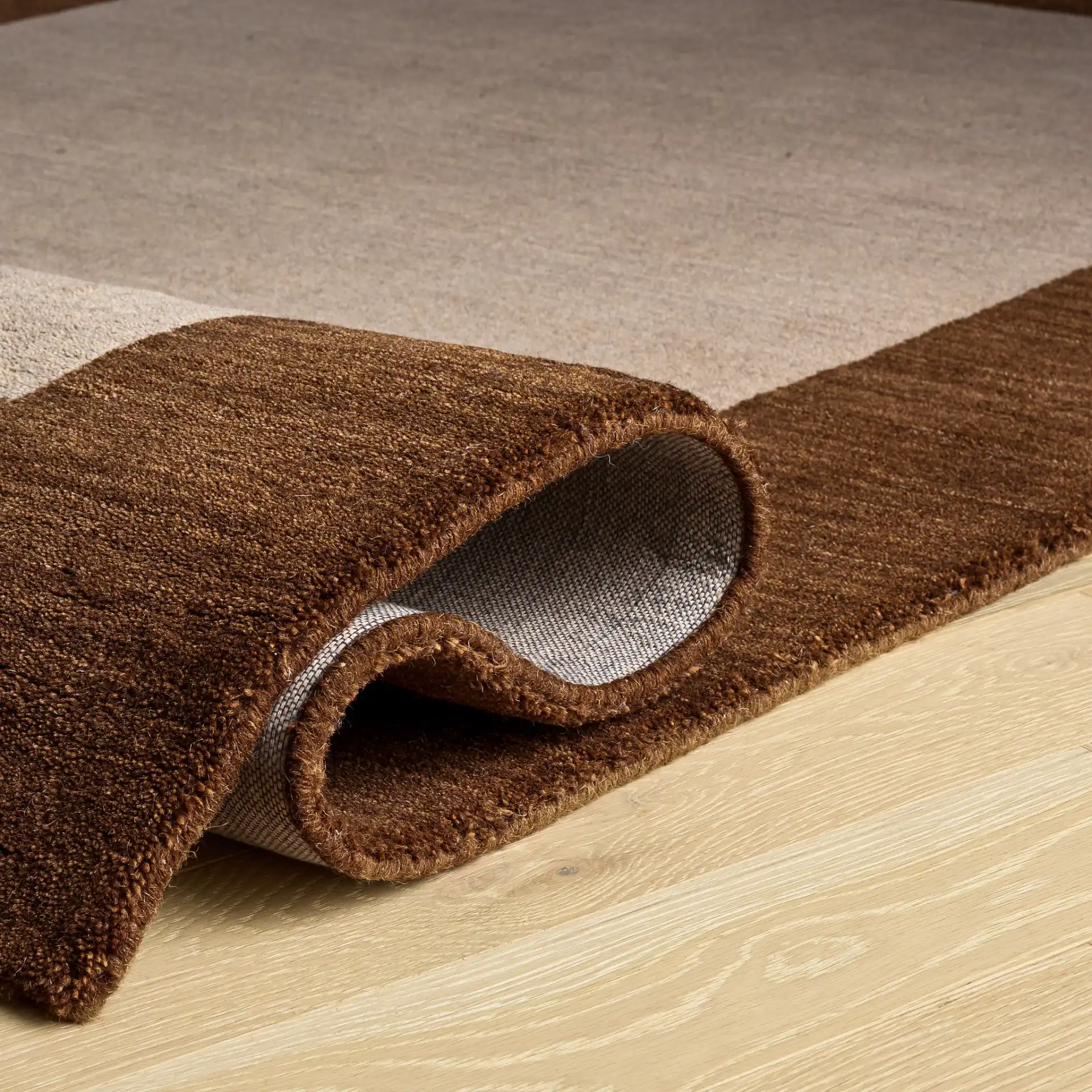 Himalaya Solid Bordered Hand-Loomed Wool Rug in Beige / Dark Brown in a styled room
