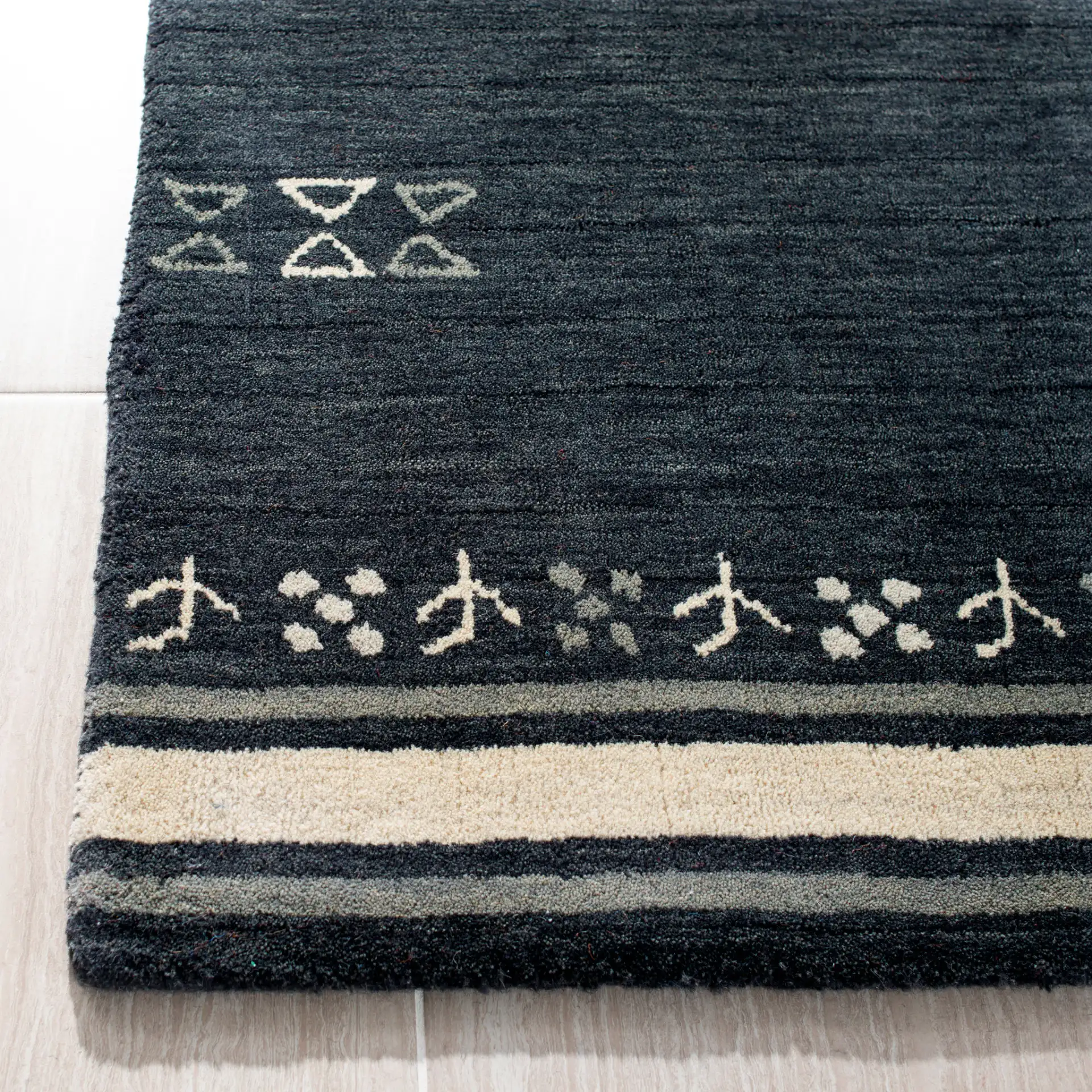 Himalaya Bordered Hand-Loomed Wool Rug in Charcoal in a styled room