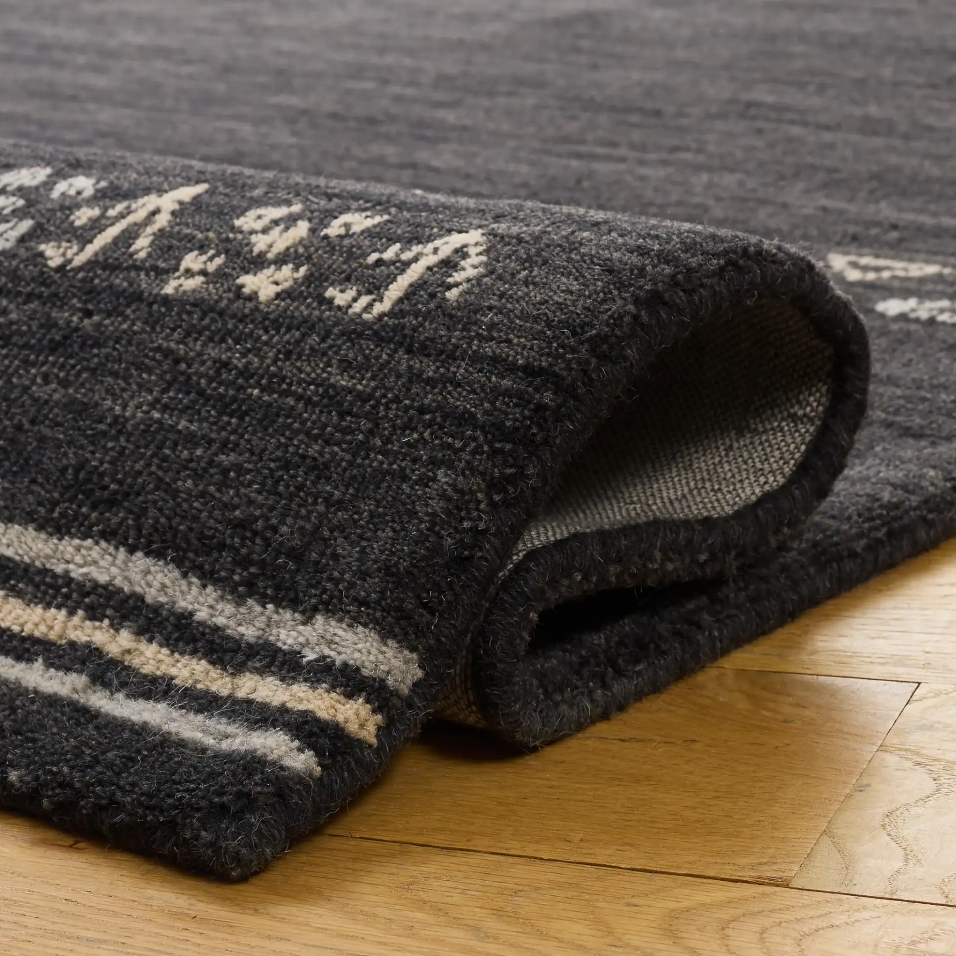 Himalaya Bordered Hand-Loomed Wool Rug in Charcoal in a styled room