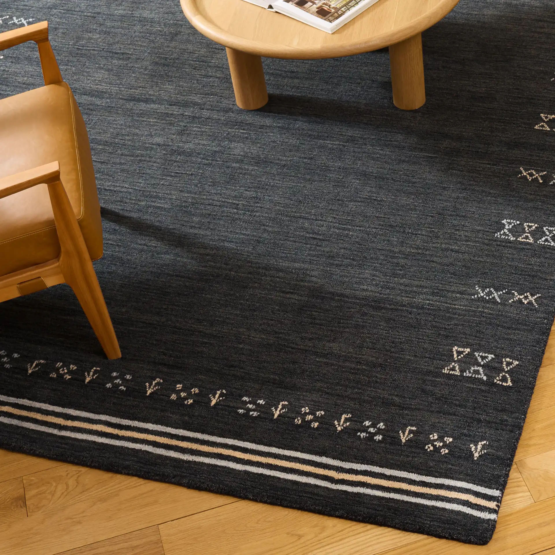 Himalaya Bordered Hand-Loomed Wool Rug in Charcoal in a styled room