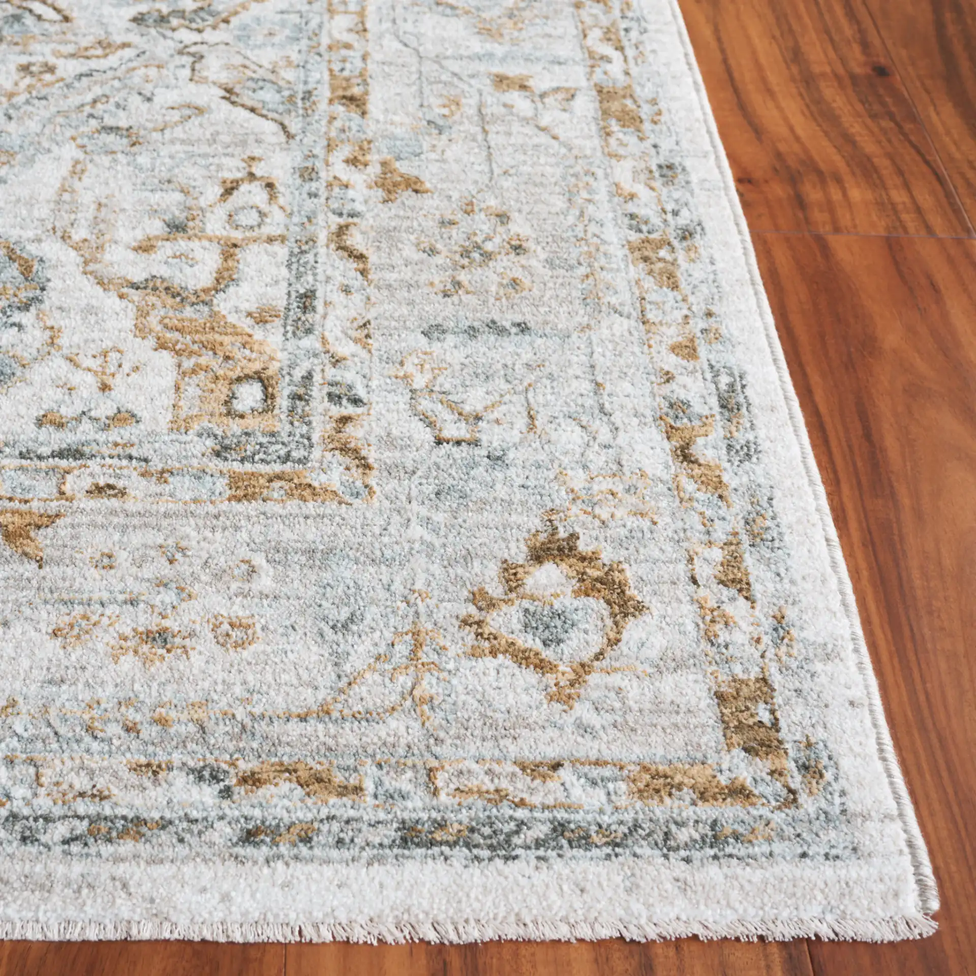 Hamilton Distressed Floral Bordered Rug in Gray / Blue in a styled room