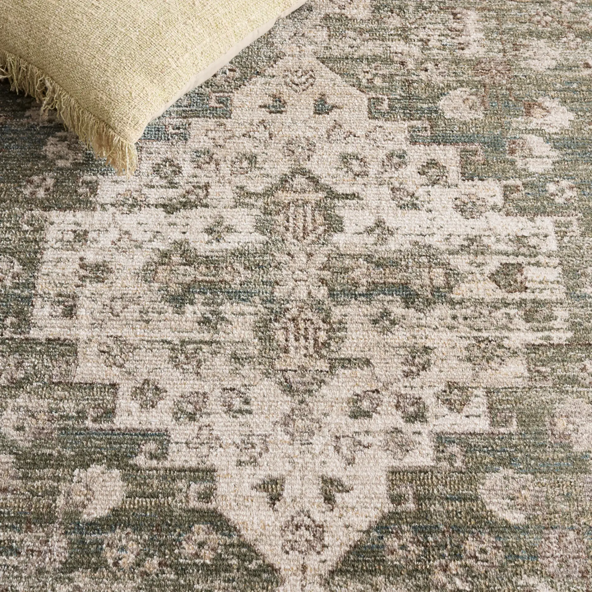 Hazel Distressed Medallion Rug in Green / Beige in a styled room