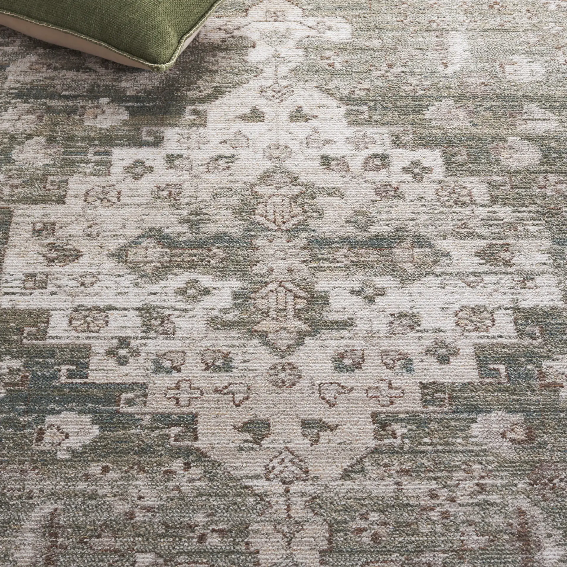 Hazel Distressed Medallion Rug in Green / Beige in a styled room