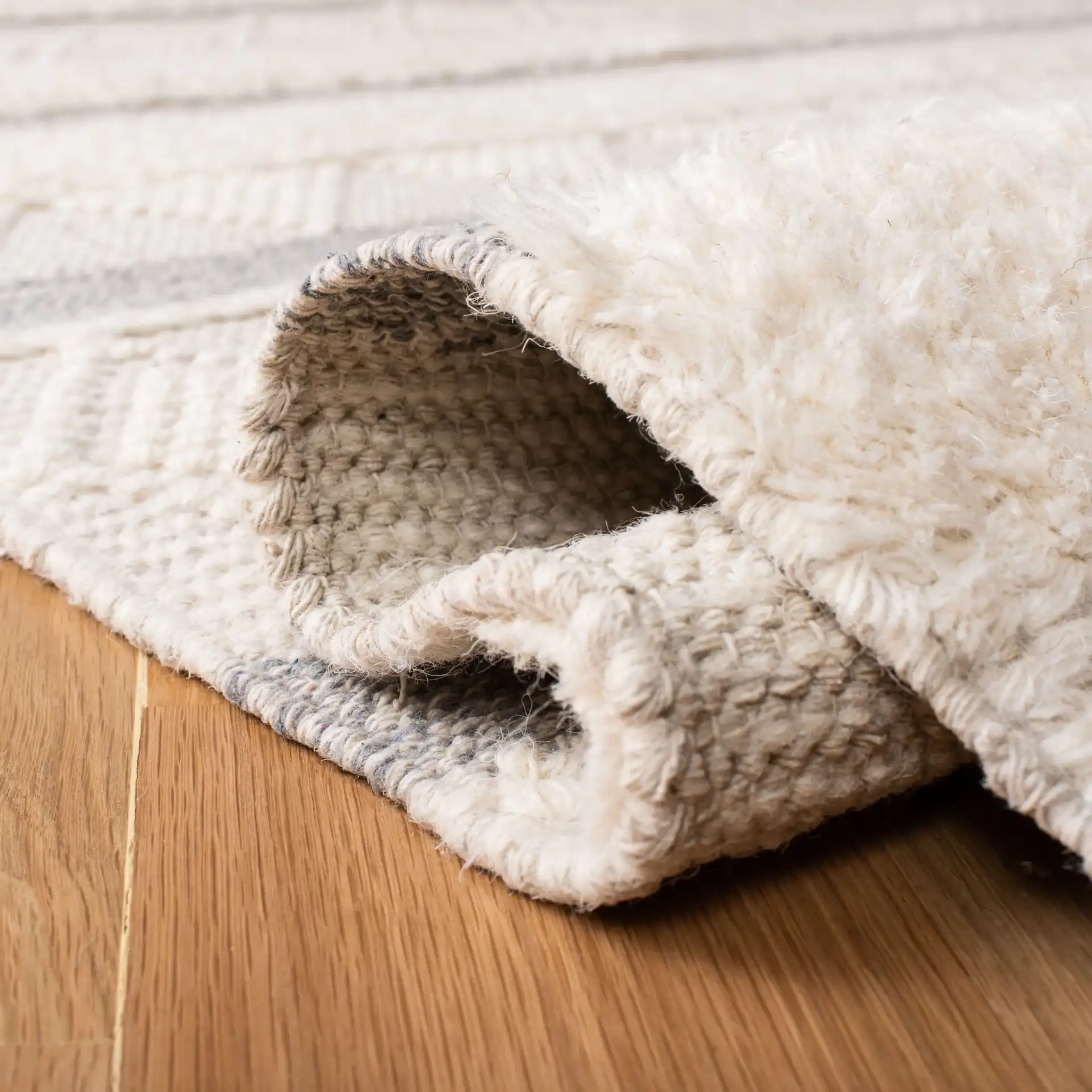 Kenya Striped Triangle Hand-Woven Wool Rug in Ivory / Gray in a styled room