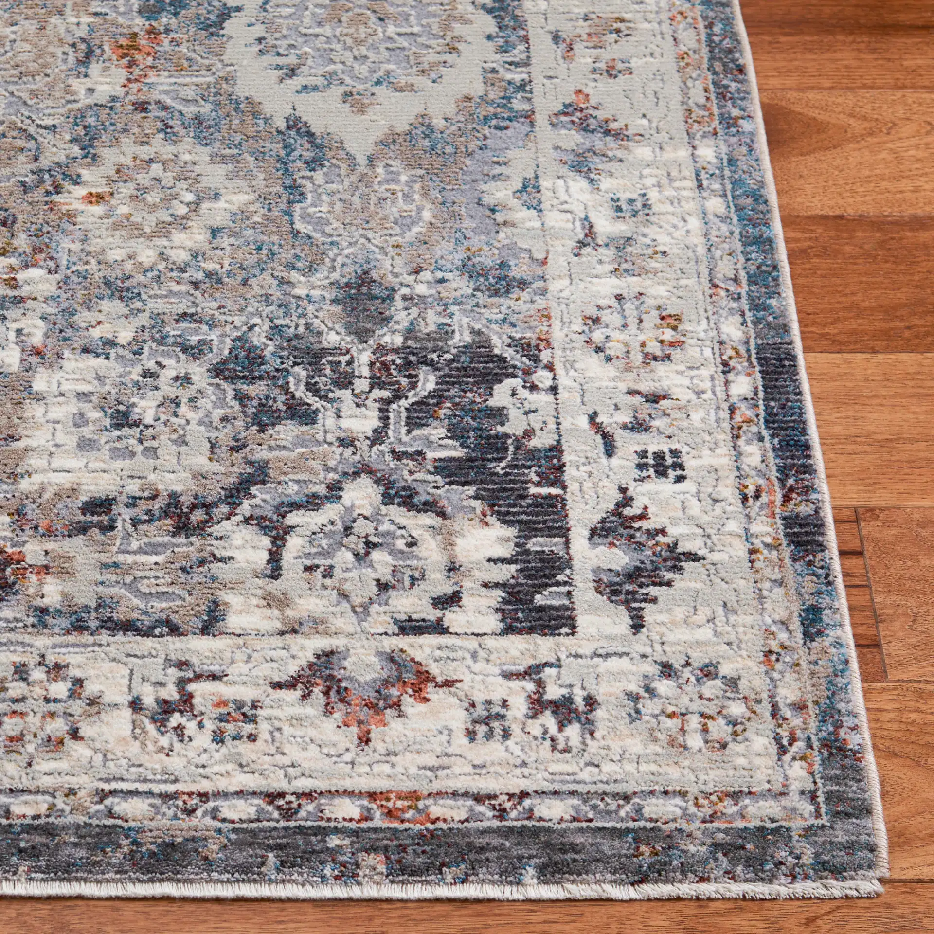 Limitee Distressed Floral Border Rug in Charcoal / Beige in a styled room