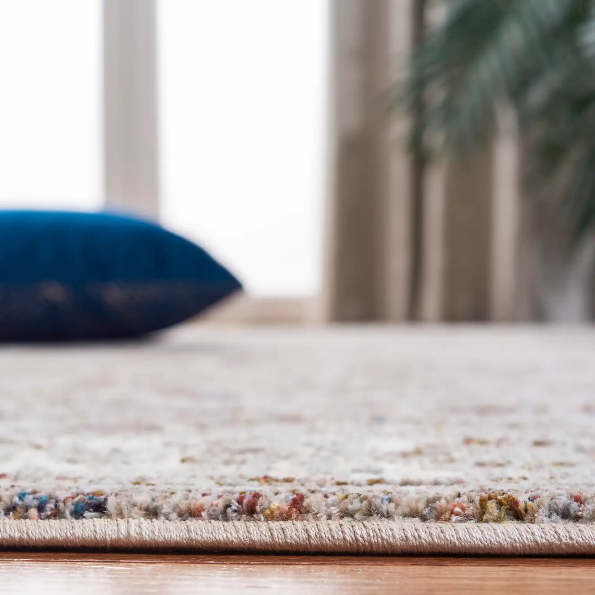 Limitee Distressed Floral Border Rug in Charcoal / Beige in a styled room