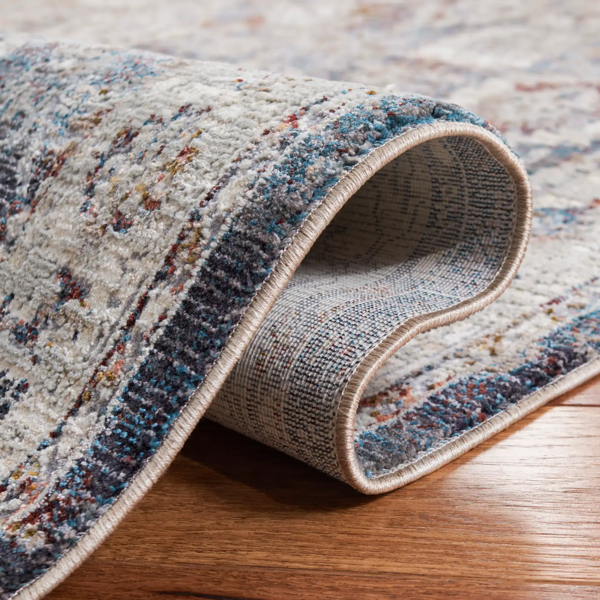 Limitee Distressed Floral Border Rug in Charcoal / Beige in a styled room