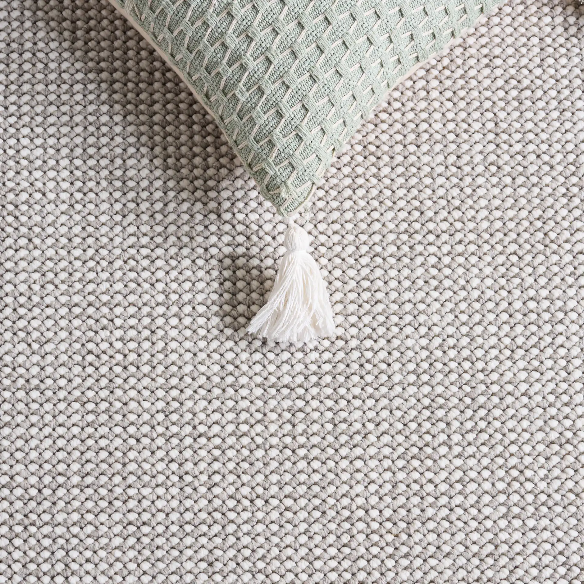 Lotus Solid Textured Rug in Light Gray / Ivory in a styled room