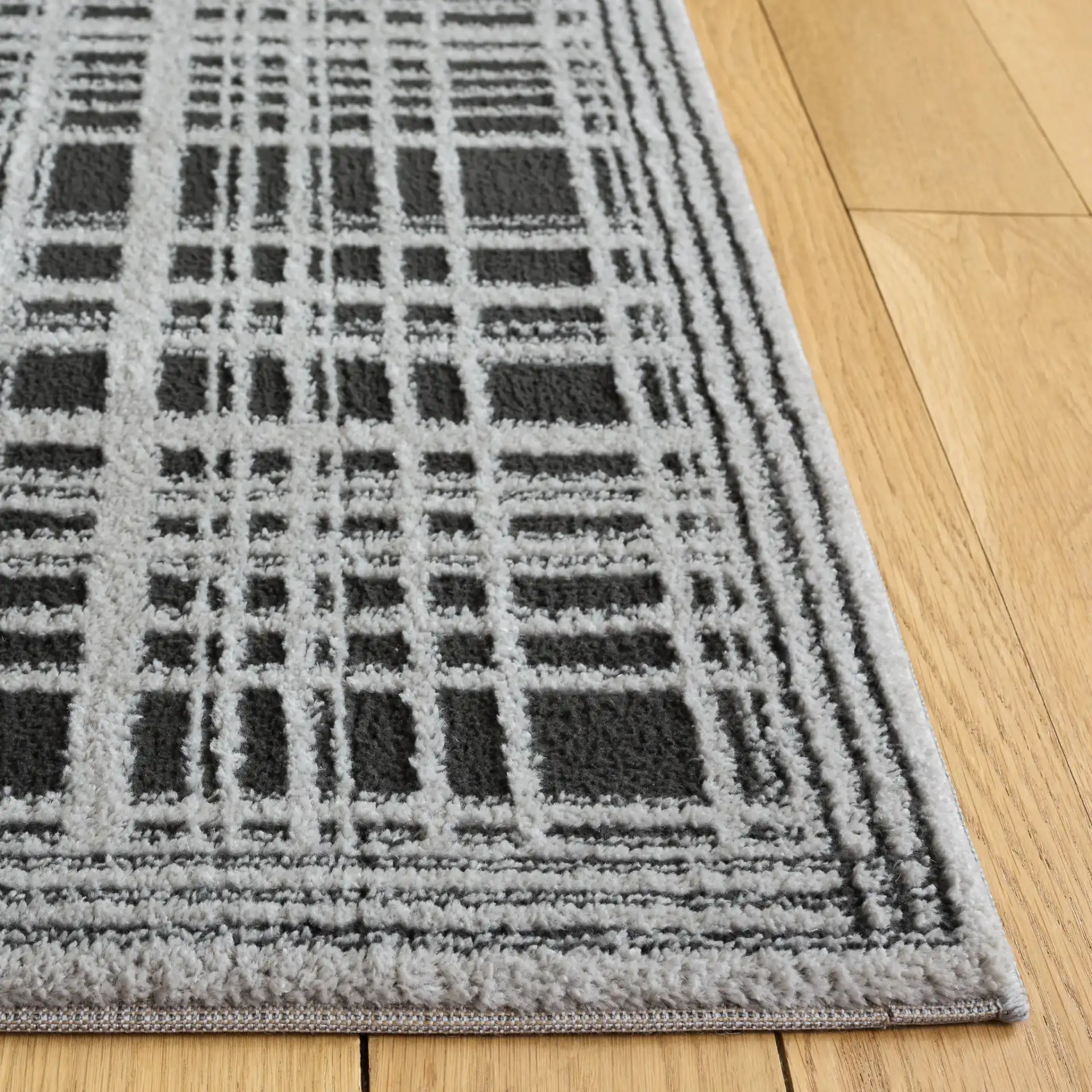 Lunara Plaid Bordered Rug in Black / Ivory in a styled room