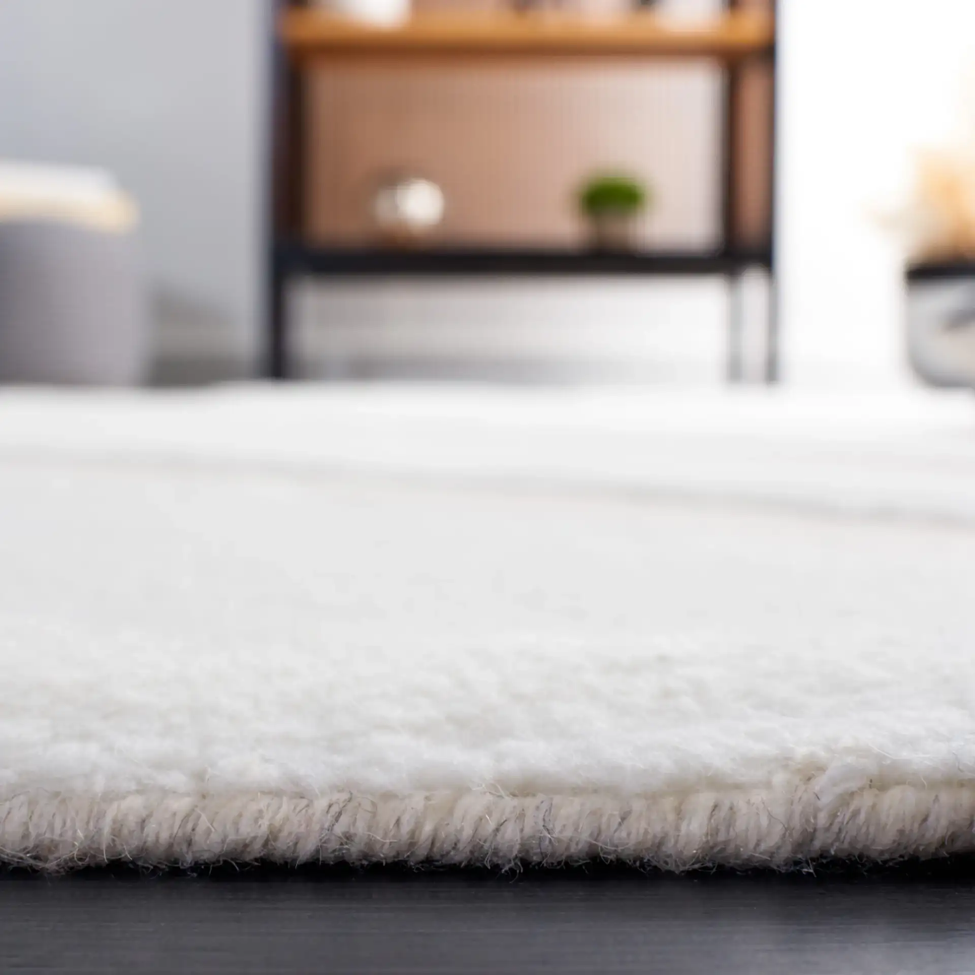 Manhattan Sweeping Arc Hand-Woven Wool Rug in Ivory / Beige in a styled room