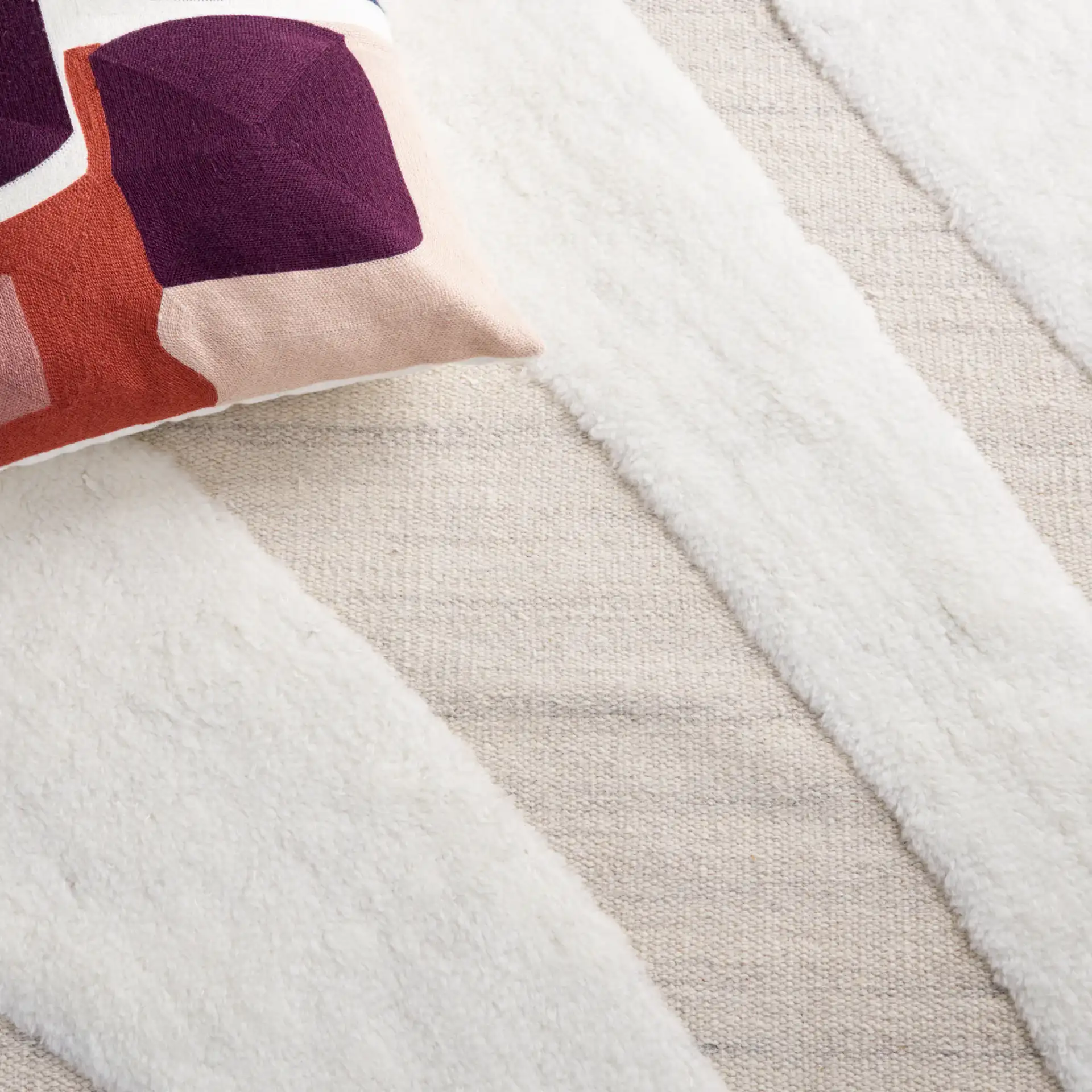 Manhattan Sweeping Arc Hand-Woven Wool Rug in Ivory / Beige in a styled room