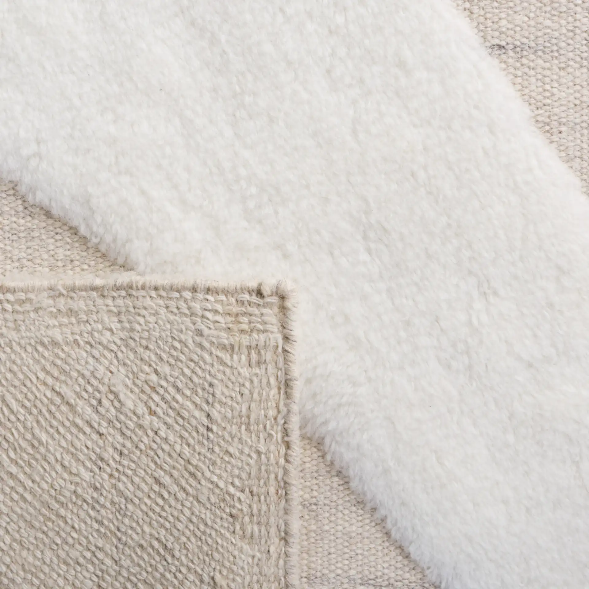 Manhattan Sweeping Arc Hand-Woven Wool Rug in Ivory / Beige in a styled room
