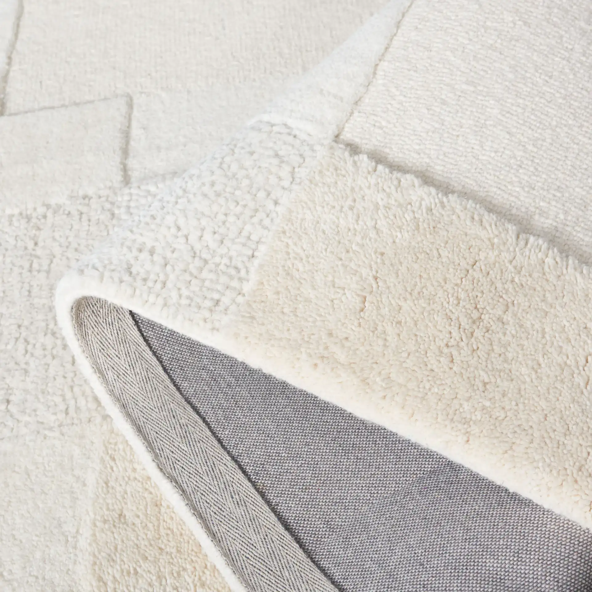 Manhattan Patchwork Hand-Tufted Wool Rug in Ivory / Beige in a styled room
