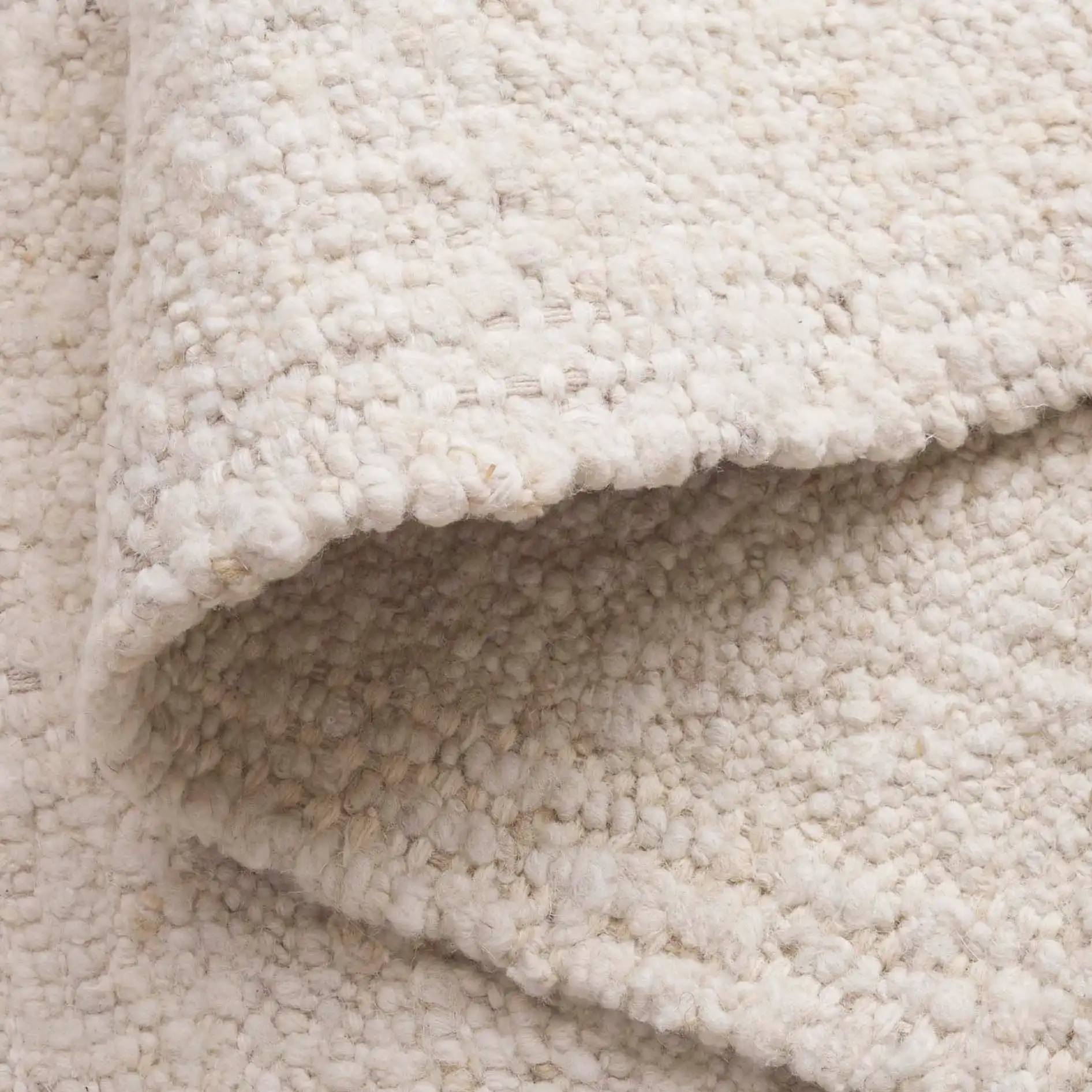 Manhattan Ribbed Solid Hand-Woven Wool Rug in Ivory in a styled room