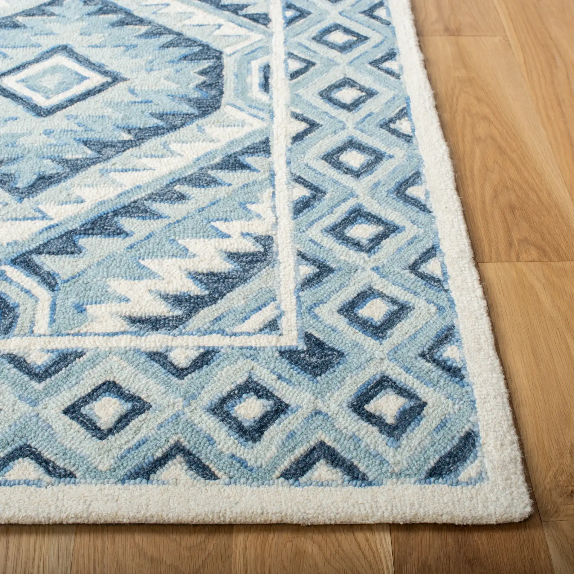 Metro Tribal Serrated Diamond Medallion Hand-Tufted Wool Rug in Blue / Ivory in a styled room